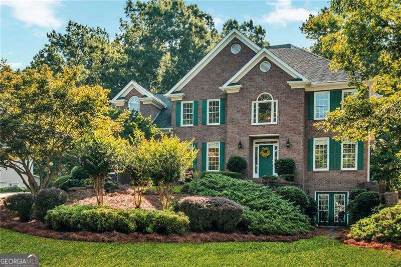Welcome to 576 Fairway Drive, located in the highly sought-after Fairways at Towne Lake-a vibrant swim/tennis community in the heart of Woodstock. This beautifully maintained 5-bedroom, 4-full-bathroom home offers thoughtful upgrades, flexible living spaces, and a peaceful backyard retreat that backs up to protected Corps of Engineers property for enhanced privacy and serene views. From the moment you arrive, the charming brick front, manicured landscaping, and blooming crepe myrtles lining the front yard create standout curb appeal. The clean, two-car garage and freshly painted exterior add to the home's inviting presence. Step inside through the main single-door front entrance to a bright two-story foyer, featuring double coat closets, upgraded lighting, and wide plank LVP flooring (installed 2019) that flows throughout the main level. The floor plan includes a formal dining area, a flexible front room, and an open-concept living room adjoining a remodeled kitchen-featuring Cambria quartz countertops, gas stove, counter-depth refrigerator (included), and upgraded cabinetry. A main-level bedroom and full bath offer flexibility for guests, work-from-home setups, or other lifestyle needs. Step out to the newly added screened-in porch and enjoy your morning coffee overlooking the level, beautifully landscaped backyard-a true outdoor oasis. Upstairs, the oversized primary suite boasts two walk-in closets and a spacious bath with dual vanities. One secondary bedroom includes a private en suite bath, while two others share a Jack-and-Jill bathroom, offering a functional and well-balanced layout. The full unfinished basement is already stubbed for a bathroom and features a separate double-door exterior entrance-ideal for future expansion into additional living space, a studio, workshop, or private suite. Property Highlights: * 5 bedrooms 4 full bathrooms * Beautifully landscaped with blooming crepe myrtles * Brick front with two-car garage * Remodeled kitchen with Cambria quartz countertops * Wide plank LVP flooring (2019) * New screened-in porch * Backs up to Corps of Engineers property * 5-year-new roof 1-year-new water heater * Double-pane wood windows * Fresh exterior paint including all trim * Swim/tennis community amenities This home combines space, style, and location in one of Towne Lake's most desirable neighborhoods. Come experience the care, comfort, and potential of 576 Fairway Drive.