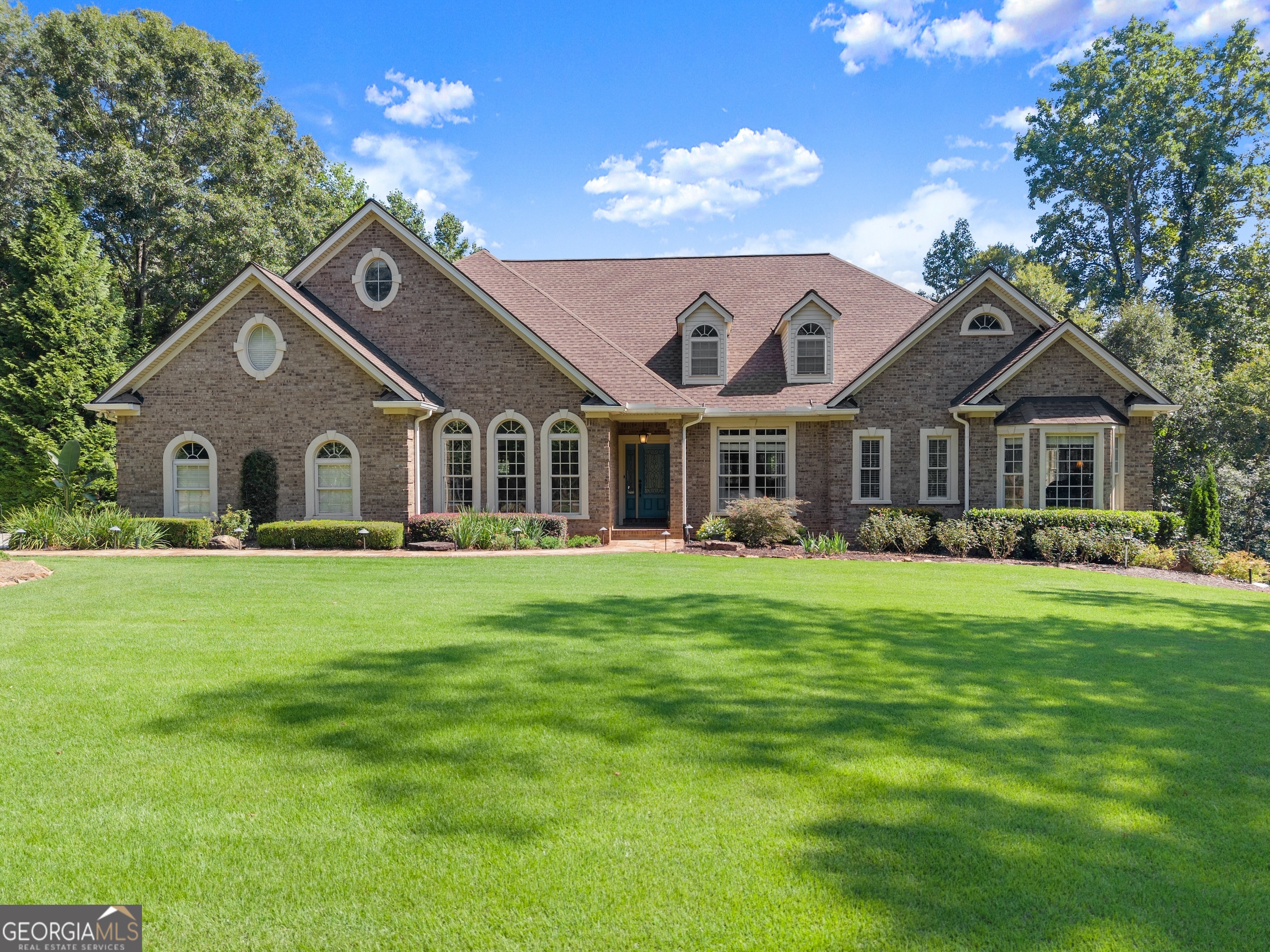 Luxury Estate on 2.24 Private Acres. Tucked within an exclusive estate lot subdivision, this sprawling 1-1/2-story ranch blends elegance with resort-style living. The main level offers 3 bedrooms, 2.5 baths, soaring 9-ft ceilings, crown molding, hardwoods, and an open floor plan. The oversized owner's suite features a private deck overlooking the pool. Upstairs includes a bonus room, full bath, and walk-in stand-up attic. A fully finished terrace level apartment adds a living area and 1.5 baths. The grounds are a showpiece-manicured front lawn, garden paradise with koi pond, trex decking, and a stunning gunite pool with pebble finish, flagstone decking and stone accents. Beyond the pool, wooded privacy leads to a fire pit retreat with stone wall and patio. A rare opportunity for refined living with privacy, beauty, and space to entertain. The property is located 1 mile from the future home of the Hoschton High School cluster.