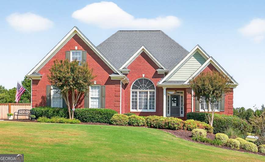 This one checks all the boxes: 3 Levels of Living (including Finished Basement In-Law Suite), Primary Bedroom on Main, Play-Ready Fenced Yard, Workshop Space, Sought-After Swim/Tennis Community, and Desirable West Jackson Location! It's all the space you need! Main Level features Formal Dining Room & Office. Family Room with soaring ceilings, brick gas fireplace, and view into the Kitchen. Kitchen boasts plenty of cabinet & counter space, newer upgraded appliances, additional Office/Coffee Station, and opens into Breakfast Room/Sunroom with natural light pouring in! Primary Suite on main with Ensuite Bath- dual vanities, separate tub/shower, and walk-in closet! Two Secondary Bedrooms on main share Full Bath. Laundry with storage cabinets & utility sink. Upstairs Suite includes Bedroom, Full Bathroom, and walk-in floored attic space for storage. FINISHED BASEMENT! Finished as In-Law Suite: Bedroom, Full Bathroom, TWO Living Areas, and Kitchenette! In-Law Suite has its own driveway & exterior entrance! Additional ~500SF Unfinished Workshop space in Basement with additional garage door (opens to secondary, In-Law Suite driveway) PLUS ~500SF of Unfinished Storage space with shelving. Take your pick for outdoor living: Main Level's expanded, wraparound deck with Trex decking & railing, Lower Level's Covered Patio space, or the flat, spacious, fenced back yard! Premium corner lot with easy access to neighborhood amenities- swimming pool, tennis courts, and playground! Easy access to 85 and all of the shops & dining of Braselton and Hoschton! Zoned for NEW Heroes Elementary & Desirable Jackson County High School!