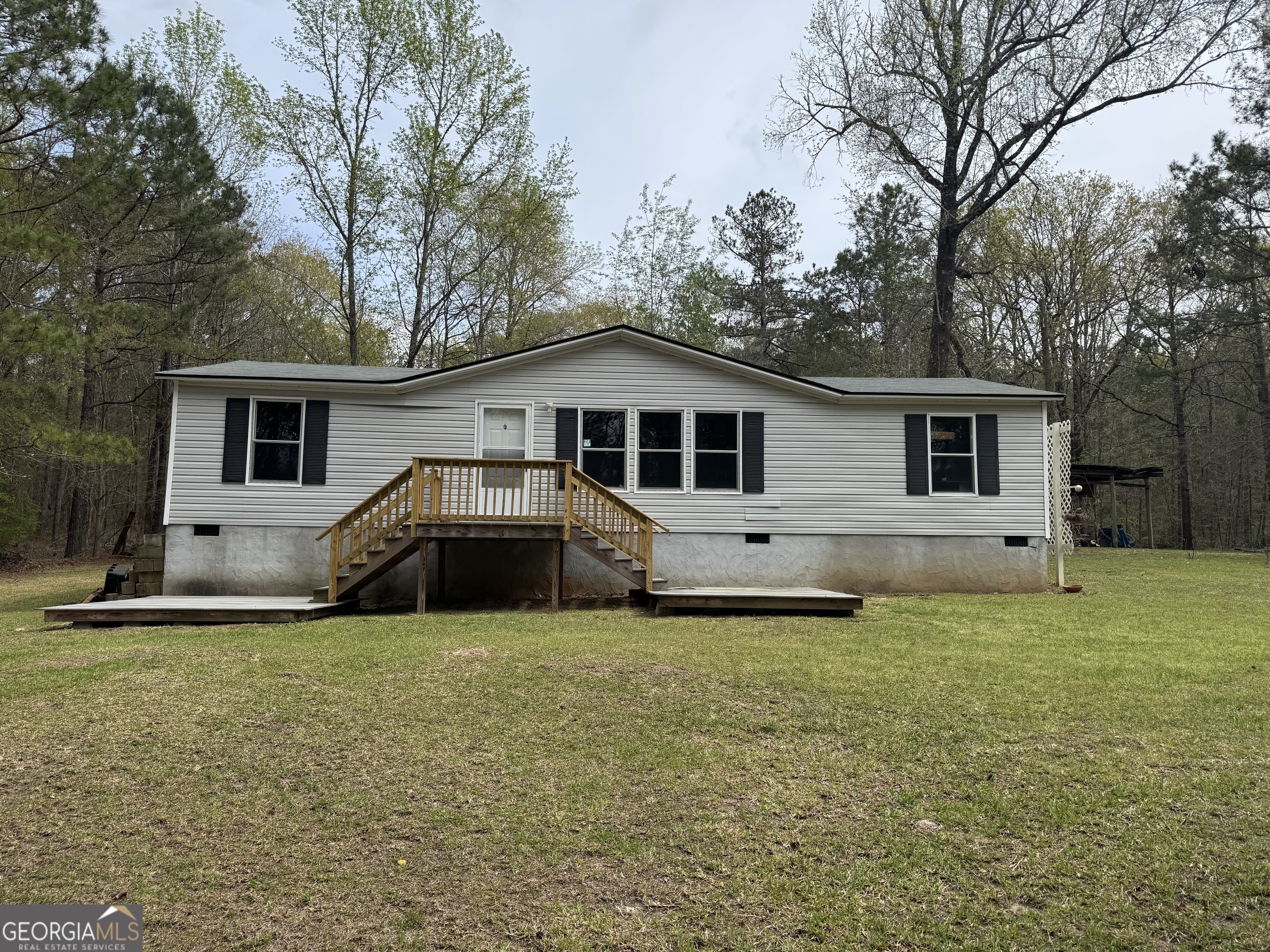 You'll love this home on 7.52 wooded acres in rural Twiggs County. 3 Bedrooms & two bathrooms with a roomy living room and kitchen. Front porch and rear porch with hand rails. Large pole barn with workshop and spacious backyard that's perfect for a garden or homesteading. The roof was replaced in 2023. Long private driveway with lots of parking. Easy travel to Gordon, Macon, and Jeffersonville.