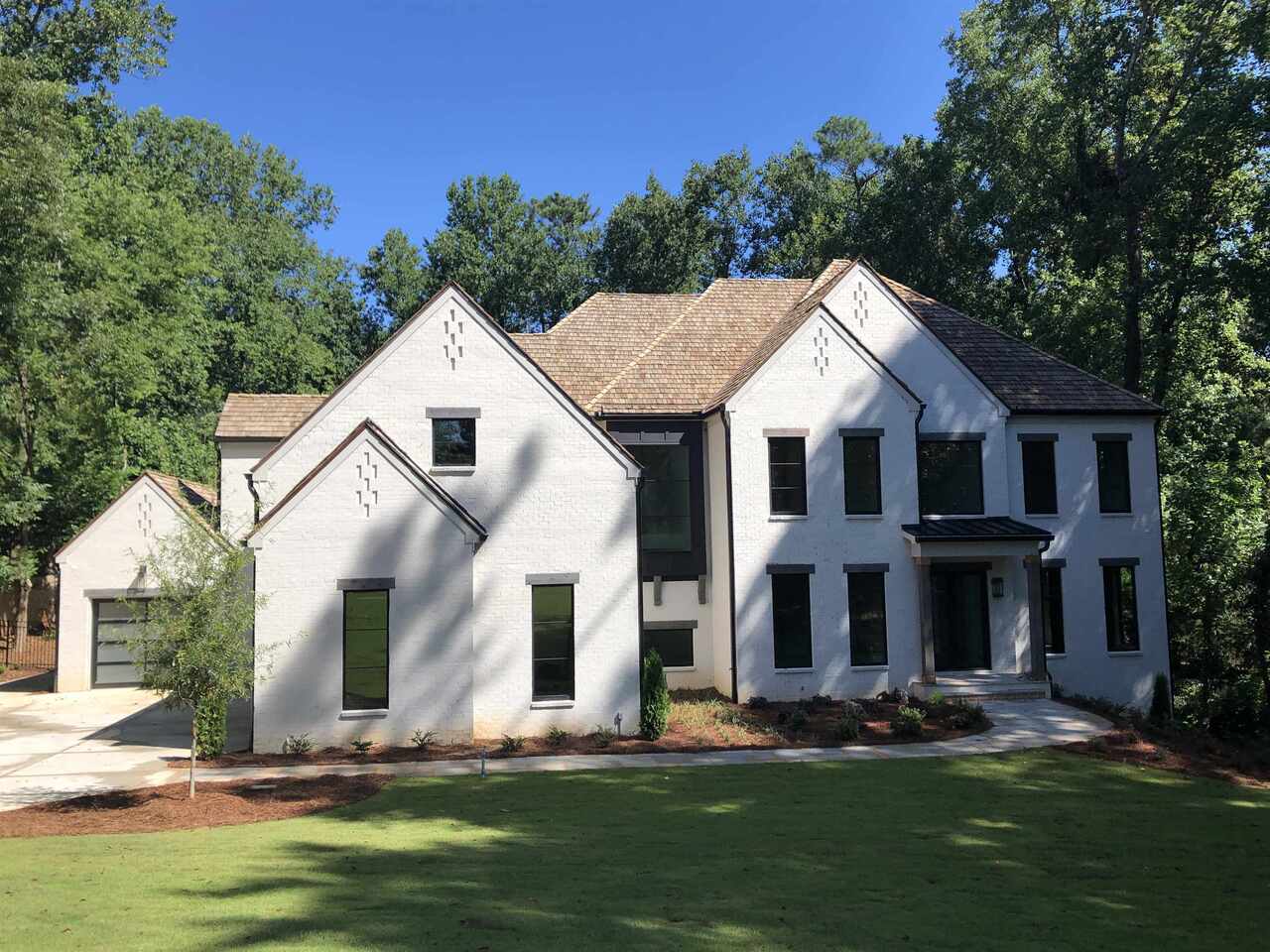 New Construction. A luxurious, contemporary home in the heart of Chastain Park with awe-inspiring views at every turn. Situated on an expansive 1+ acre lot and enveloped by natural forest, this stunning estate boasts maximum privacy with ultimate luxury. Retreat to the tranquil yard featuring a sparkling pool seamlessly blending into the horizon and ample patio and grass space for dining and/or lounging al fresco. Features include lavish dual master suites with dual baths large closets, well-appointed guest suites, elevator, movie theater, gym, lower-level game/entertaining, two laundry rooms, Four car garage, au pair suite, multiple fireplaces, playroom, covered porch to walk out heated Pebble-Tec pool and spa. 4-sided brick with white mortar, metal windows, 6" rounded gutters, Cedar Shake roof, white oak 7' floors and so much more. Only moments from Chastain Park, Buckhead, Vinings and downtown, this Chastain Park estate is truly one to behold. Take the elevator to the basement and WOW you see this absolutely amazing, finished basement. Kitchen features white marble, high end appliances like Wolf, Sub-Zero, Bosch, Ice Maker, Wine cooler, and walk in pantry. Covered porch overlooks the in-ground pool. This home has so much to offer from upgraded trim to lighting package to cabinets and appliances. Are you looking for a larger garage? We have a 4-car garage! This is a very private lot and custom home that is second to nothing. New Construction photos are from previous build and for reference only.