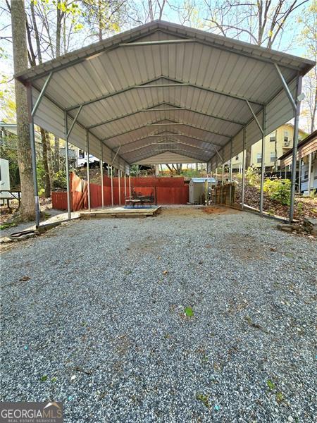Welcome to your perfect weekend retreat or full-time RV haven! This meticulously maintained .07-acre lot is move-in ready and packed with features that make outdoor living effortless and enjoyable. A brand new privacy fence encloses the back and sides, offering a sense of seclusion and security. The property boasts fresh gravel, a cozy patio area complete with furniture and a relaxing swing, and a massive 12ft wide x 35ft long x 15ft high RV cover - ideal for protecting your rig year-round. You'll also find a convenient outdoor storage building, perfect for stowing gear, tools, or seasonal items. Located in a gated community, this lot includes access to incredible amenities like waste management, water/sewage, wireless internet, and full power hookups. Enjoy life by the water with access to a beautiful lake and a peaceful pond, or cool off in two sparkling swimming pools. The community also features a recreation area, general store, and so much more. Whether you're seeking a weekend escape or your next full-time lifestyle move, this property delivers comfort, convenience, and a true sense of community. Don't miss out!