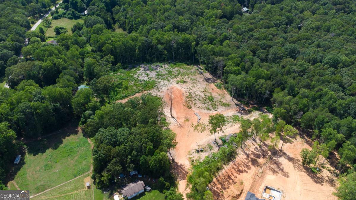 Stunning 11+ Acre Property in the Heart of Mill Creek - Ready for Your Dream Build This beautiful 11.17-acre tract offers a rare opportunity for a builder, developer, or private buyer to create something truly special. Whether you're envisioning multiple homes or a private family compound, this land offers the flexibility and setting to make it happen. Tucked away in the peaceful Mill Creek area between Dawsonville and Dahlonega, the property features a long dirt driveway that winds deep into the acreage, creating a private, secluded retreat set far back from the road. Much of the brush and trees have already been cleared, offering a head start on development and showcasing the property's natural topography. A gentle spring meanders through the northern section of the land, enhancing the property's tranquil atmosphere and adding to its appeal for nature lovers or those dreaming of a serene homestead. With elevated ridges offering potential home sites and a luxury home being built on adjacent land, this land is perfectly positioned for upscale development or a private luxury residence. Whether you build one breathtaking home perched on the ridge or several thoughtfully placed houses, this property is ready to bring your vision to life.