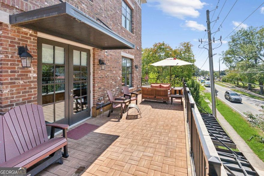 Welcome to your Downtown Woodstock dream home! This exceptional luxury townhome offers 3,454 square feet of beautifully designed space across three levels, with 4 spacious bedrooms and 4 full bathrooms. Every inch of this residence has been thoughtfully crafted for comfort, style, and convenience.    Step inside from the private alley into your sealed-floor garage, complete with a Tesla EV charging station and private elevator access to all levels of the home. Inside, you'll find soaring ceilings, expansive windows that flood the space with natural light, and premium finishes throughout.    The chef's kitchen is the heart of the home, featuring solid surface countertops, high-end cabinetry, and an open-concept layout that flows seamlessly into the main living and dining areas. A built-in wine bar adds a sophisticated touch, perfect for entertaining or a relaxing evening at home. The living room is anchored by a sleek tiled fireplace with an adjustable TV mount above the mantle, combining modern design with cozy ambiance.    From the living room, step out onto your expansive 40-foot-wide private deck, spanning the full length of the home - a rare outdoor space ideal for relaxing, dining al fresco, or enjoying the energy of Downtown Woodstock below.    Each bedroom is generously sized and thoughtfully appointed with custom California Closets, providing elegant and functional storage solutions. Additional highlights include a large pantry, multiple utility areas, abundant storage throughout, and refined finishes that elevate every space.    Located in the heart of vibrant Downtown Woodstock, this home places you within walking distance to everything the community has to offer. Just a 6-minute walk to the amphitheater, where you can enjoy a lively summer concert series, and only 10 minutes on foot to over 30 restaurants, wine tasting rooms, craft breweries, boutique shops, entertainment venues, and more.    Directly across the street, Adair Park serves as a social and cultural hub, hosting community favorites like Wine Down Wednesday and Trivia Thursday. Just around the corner, the Woodstock Arts campus features a gallery, black box theater, and outdoor event green with year-round performances and exhibits. You'll also enjoy access to the seasonal farmers market, artisan fairs, and frequent festivals that make downtown living exciting and community-driven.    This golf-cart-friendly neighborhood makes it easy to explore the area, whether you're heading to dinner, a concert, or simply enjoying a ride through the scenic streets. Outdoor enthusiasts will love nearby Rope Mill Park with wooded trails, mountain biking, and river access for kayaking and paddleboarding. For additional shopping, The Outlet Shoppes at Atlanta are just a short drive away, offering premium brands and retail options.    This is more than just a home - it's a lifestyle. A rare opportunity to own a low-maintenance, high-style residence in one of Georgia's most desirable and walkable downtowns. Luxury, community, creativity, and convenience come together in one extraordinary place. This is a live/work townhome with a bottom portion dedicated to a commercial business. All street parking on Main Street, Linton Street, and Adair Park are unrestricted and available for homeowners and guests in addition to the 2 car garage.    Schedule your private showing today and experience Downtown Woodstock living at its finest!