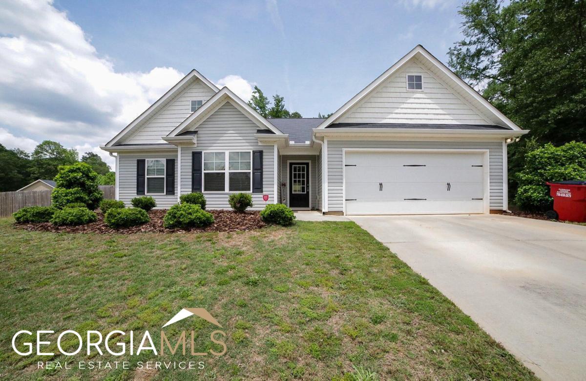 Hosted in Banks County's premier community, Hebron Place, is a pristine, like-new craftsman that's ready to show you what it's all about. Just a few years young, built in 2019, this easy-living ranch boasts an open concept highlighted with upgraded finishes presenting key elements that create this compelling home. Crafted with an ever-desirable, single-level living concept , this gracious plan hosts a welcoming foyer that effortlessly transitions to the great room where the exciting details come alive. Durable luxury vinyl plank flooring, fireplace, decorative light fixtures, designer's choice paint palette, double paned windows accompanied by 2in. blinds, and 9 ft. ceilings are just a few of the standout features that adorn this home. The spacious design maximizes every inch of usable space, and creates the perfect backdrop for entertaining. With the great room being completely open to the kitchen, the home chef will never have an issue overseeing their guest. Featuring striking appointments and providing ample space, whipping up gourmet cuisine will be a breeze. This sparkling kitchen is equipped with an abundance of custom stained cabinets, sleek granite counter tops that extend to the oversized island, large pantry with shelving system, and a spacious breakfast bar that offers extra seating. The kitchen also lends space to the sunroom-styled dining room perfect for enjoying your morning cup of coffee as you take in the territorial views of the private rear yard. Comprised of a split-bedroom configuration places the owners retreat just off the great room, with two accessory bedrooms and a perfectly detailed full bath spanning the front of the home. To your delight, the owner's suite is upgraded with all the expected accoutrements such as space for large furniture, lofty tray ceilings, plush carpet flooring, spacious closet with shelving system and a full bath. Well appointed, the ensuite bath was enhanced with an granite, dual-sink vanity, separate shower, and garden tub encouraging relaxation. With Summer right around the corner, enjoy a little time outdoors or hosting BBQs on the open-air patio overlooking the privacy-fenced rear yard. All of these dynamic features are perfectly enveloped on an expansive 1.01 acre corner lot, adorned with professional landscaping adding to its curb appeal. Last, but certainly not least, this homes desirable location places it within 8 miles to Banks Crossing, Tanger Outlets shopping and I-85. If you're searching for a well-kept, newer home boasting upgraded appointments, then 105 Meadow Creek Court is calling you home!