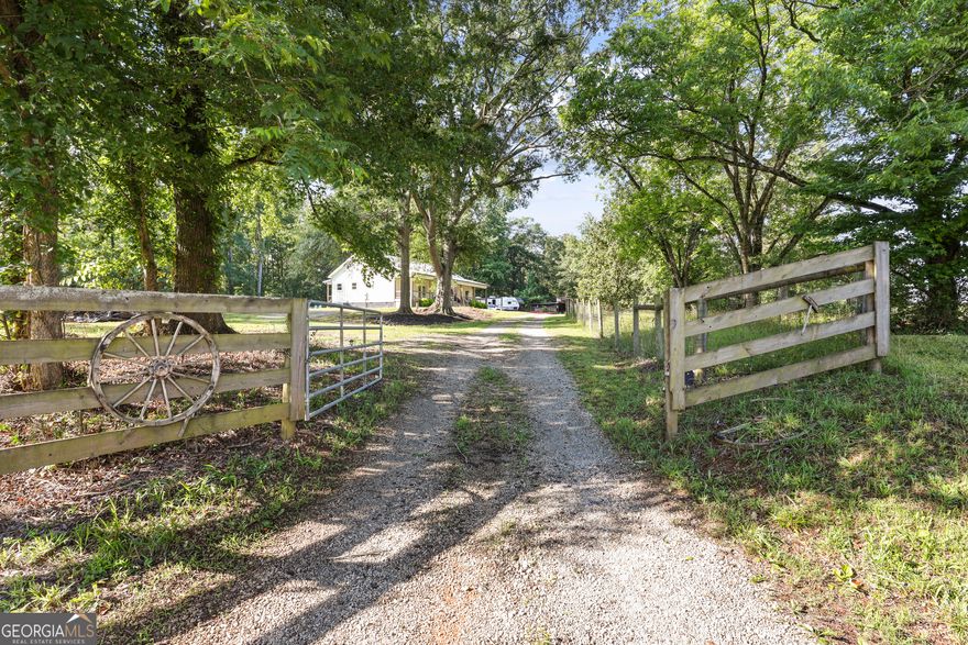 Modern Farmhouse on 7+ Acres - Built with Heart in 2022!  Welcome to 1571 Sunshine Road, where timeless style meets thoughtful design. Situated on the Franklin/Stephens County line, this modern farmhouse rests on over 7 acres of privacy, beauty, and functionality. Built in 2022 with love and attention to every detail, the home begins with an iconic 60-ft wide, 8-ft deep front porch-perfect for rocking chairs, sweet tea, and great conversations.    Out back, you'll find a 15x36 screened-in porch that lives like a second family room-currently used as a dining and gathering space-plus a separate grilling porch just off the kitchen. One more outdoor space you'll love: the hot tub tucked out back (just keep an eye out for the deer who like to watch!).    Arrive through the gated entry flanked by classic board fencing and towering oak trees lining the driveway. This property once held an old homeplace, and thoughtful nods to its history remain, including reclaimed doors-one of which now leads to the walk-in pantry.    Inside, the open floor plan features luxury plank flooring, a light-filled living and dining area, and a dream kitchen with a large island (seating for four), a 5-burner gas range, and high-end finishes. An oversized laundry room with extra work space connects to the owner's suite for ultimate convenience.    The owner's suite is a private retreat, featuring barn-style sliding doors and an en suite bath with double vanities and a stunning walk-in tile shower-a luxurious rustic showpiece.    With vertical board-and-batten Hardie siding, scenic acreage, and a one-of-a-kind layout, this home offers the best of modern design in a peaceful, country setting.    Note: The neighboring property is currently using the same driveway but is in the process of installing their own private access from the paved road.