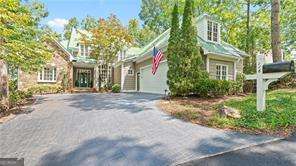 Don't miss this spectacularly renovated Chestatee residence showcasing sweeping Lake Lanier and mountain views from nearly every room. Designed for comfort, elegance, and ease of living, this home is nestled in the heart of Chestatee-one of North Georgia's most prestigious communities. Residents enjoy access to an award-winning Denis Griffiths, Jr. 18-hole golf course, a private marina with boat slips, scenic walking trails, a lakeside pavilion, and an inviting clubhouse with dining and social spaces. Here, every day feels like a vacation. Set on a low-maintenance lot, this ranch-style home offers privacy and serenity with its wooded backdrop and expansive water vistas. The main level features three generously sized bedrooms, each with a private en-suite bath-perfect for hosting overnight guests while maintaining personal comfort. The primary suite is truly exceptional, boasting panoramic lake views, two spacious walk-in closets, and a cedar-lined closet. Custom built-in cabinetry provides abundant storage, while the newly completed spa-like bath is a luxurious retreat. Relax in the freestanding soaking tub or step into the oversized shower with rain head and handheld sprayer. Dual vanities with quartz counters, dramatic mirrors, and layered lighting create both style and function. From the bedroom, enjoy direct access to a private screened porch-an ideal spot for morning coffee while taking in the view. The chef's kitchen blends beauty and functionality with an oversized island, prep sink, and new gas cooktop with pot filler. Champagne Bronze Delta fixtures add refinement, while the open design flows into the vaulted keeping room with built-in cabinetry, a fireplace, and more stunning lake views. Hardwood flooring spans the main level living spaces, and upgraded LED recessed lighting throughout allows you to adjust ambiance from warm and inviting to crisp and modern. On the terrace level, you'll find generous entertaining space including a fireside multipurpose room, pool table area, and a private office with custom wainscoting-ideal for working remotely or managing personal affairs. Guests will appreciate the spacious bedroom with its en-suite bath, walk-in closet, and private covered patio. For hobbyists, collectors, or car enthusiasts, the home features dual oversized garages with space for multiple vehicles, a golf cart, or even a workshop. Almost every fixture in the home has been updated with designer lighting and fans, giving the interiors a current, polished aesthetic. The home's thoughtful design and abundant storage make it as practical as it is beautiful. With shopping and dining just minutes away-including North Georgia Premium Outlets only six miles from your door-plus easy access to GA 400 for trips into Atlanta and the airport, this location offers both convenience and tranquility. This is more than a home-it's a lifestyle designed for those who appreciate refinement, comfort, and the luxury of low-maintenance living on Lake Lanier.