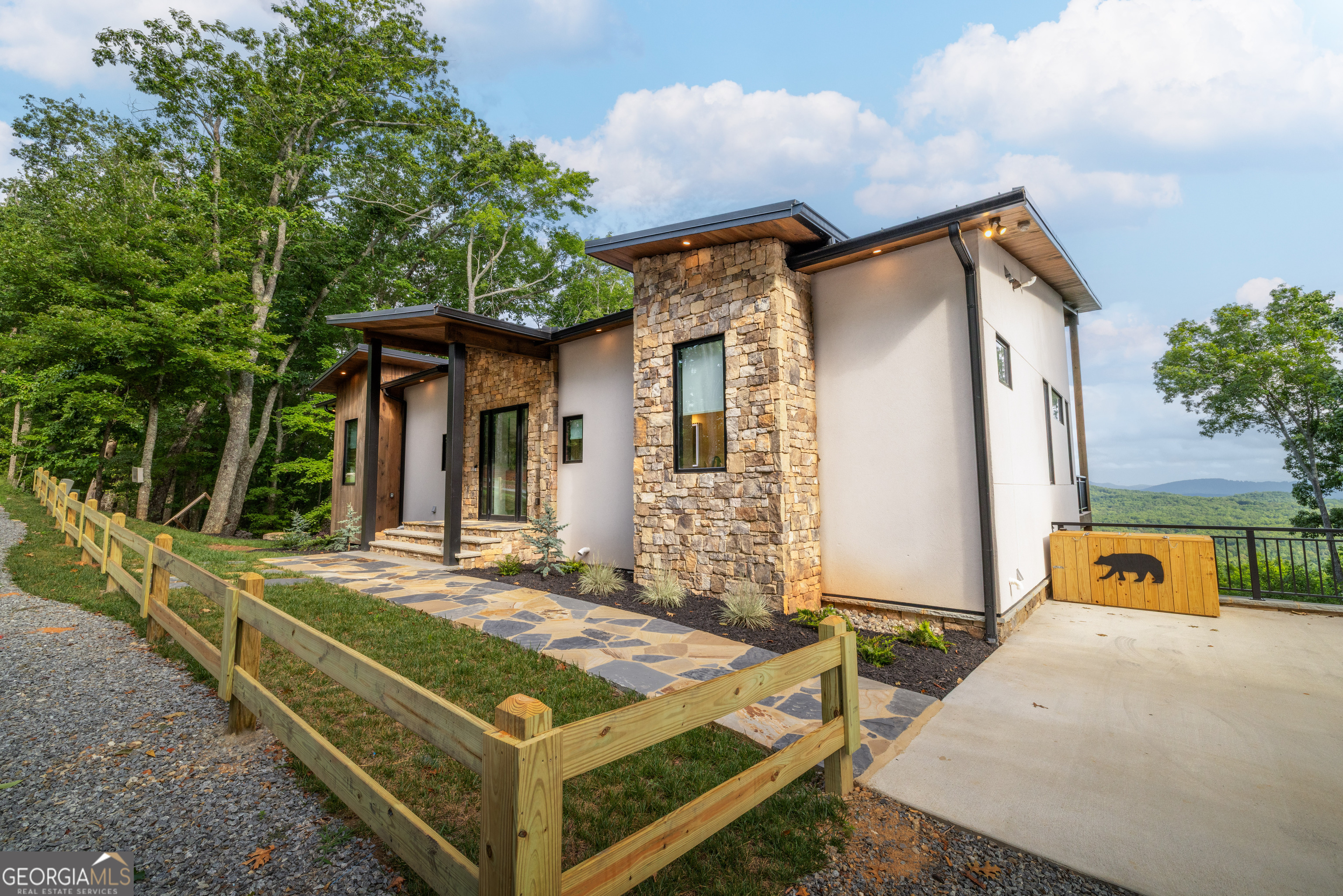 Mountain modern meets rustic chalet charm! This brand new construction located in the highly desired Elevation at Scouts Ridge subdivision is a custom design by Tony Boyatt and built by Tommy Wosyluk. Featured in the 2024 Blue Ridge Mountain Parade of Homes, this home boasts 4 bedrooms and 4.5 bathrooms. Floor to ceiling windows highlight the long range, layered mountain views that serve as a backdrop to each room. Natural stone and rustic wood are accented by steel beams and custom metal work throughout. The home showcases warm & comfortable living areas that are open & spacious, perfect for year round entertaining of your guests. The living areas open to expansive deck space overlooking the beautiful Blue Ridge Mountains. Situated at the top of the ridge and surrounded by Boy Scout protected land, you are just a short drive to shops, restaurants & Lake Nottely while maintaining a sense of privacy at this mountain getaway. Professionally furnished by Krystal Sumner, this home is being sold turn key!