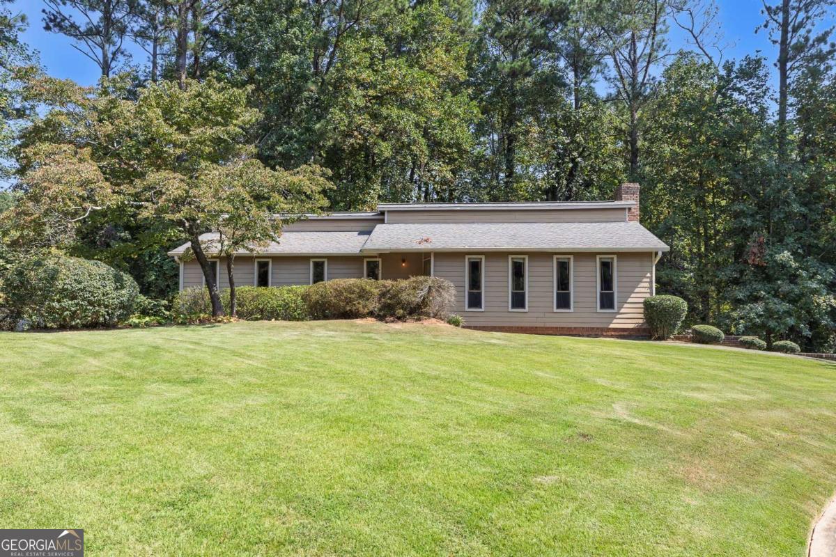 This charming ranch home is tucked away in a cul-de-sac in Woodstock, offering plenty of space for both parking and guest parking. Conveniently located near shopping, dining, and entertainment, the property combines comfort with convenience. Lovingly maintained by the owner, the home is move-in ready and, with a few cosmetic updates, can easily be refreshed to suit today's style. Step inside to a spacious family room highlighted by exposed ceiling beams and a brick fireplace, creating a warm and inviting atmosphere. The eat-in kitchen features classic wood cabinetry, a new gas range, and a new dishwasher, with direct access to the rear deck-perfect for grilling while overlooking the wooded backyard. The primary bedroom includes an ensuite bath with an updated shower, while two additional bedrooms share a hall bath. The unfinished lower level offers laundry hookups and flexible space that can be finished to create additional living areas or kept as-is for storage. On the other side, a drive-under garage provides ample room for parking and includes an area suitable for a workshop. With just a touch of vision and effort, this home has all the potential to become your dream retreat in a prime Woodstock location.