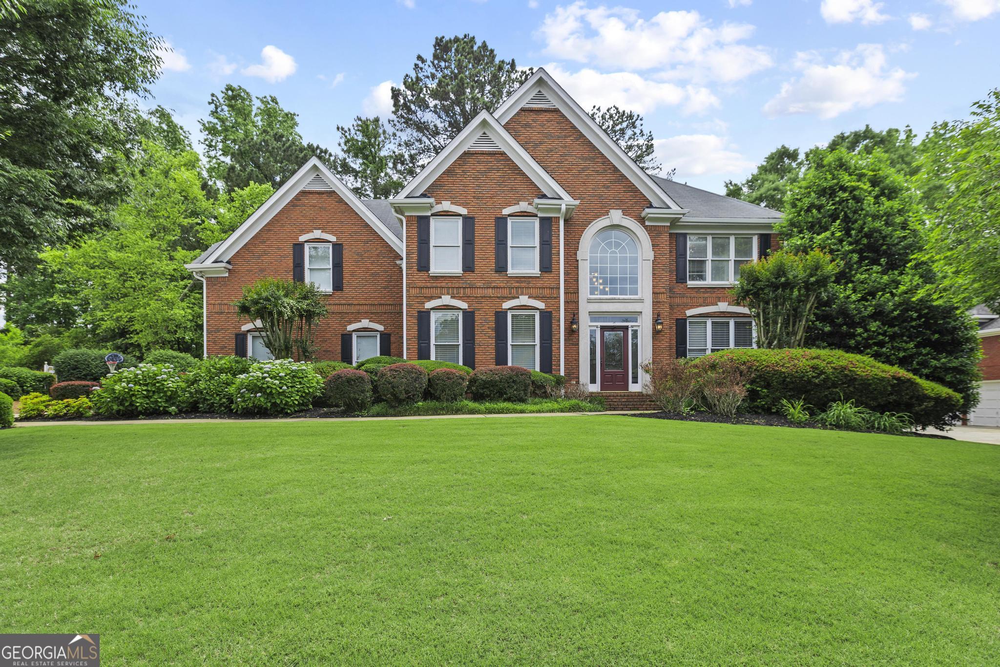 This beautifully maintained brick home sits in one of East Cobb's most desirable swim and tennis neighborhoods, offering timeless charm, thoughtful updates, and an inviting layout designed for comfortable family living. Inside, you'll find fresh designer paint, updated lighting, gleaming hardwood floors, and rich millwork that lend warmth and character throughout the main level. A grand foyer opens to a formal living room-ideal as a home office-and an elegant dining room ready for special occasions. The heart of the home is a chef's kitchen with granite countertops, stainless steel appliances, and a breakfast bar that flows into a cozy fireside family room and sunny breakfast area. Step outside to a charming Charleston-style porch-a private escape perfect for relaxing or entertaining. Upstairs, the expansive primary suite offers a luxurious retreat with a double-sided fireplace, a generous sitting area or second office, large walk-in closet, and a spa-like bathroom with soaking tub and updated separate shower. Three additional bedrooms and two full bathrooms are updated and provide plenty of space. The finished terrace level offers even more flexibility, featuring an open-concept living area, a kitchenette, a full bathroom, and a bonus room that could serve as a fifth bedroom, office, or gym. Ample dry storage completes the space. Out back, enjoy a large, fully fenced yard-ideal for gatherings, playtime, or peaceful afternoons outdoors. New water heater, gutters, and MORE! Just a short walk to neighborhood amenities, this home blends comfort, style, and community in one exceptional location.