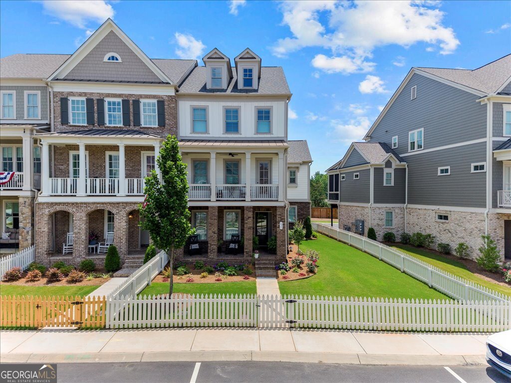 Luxury 3 Bed / 3.5 Bath Corner Townhome with High-End Finishes & Premier Amenities -Super Close to Downtown Woodstock in Sought-After South on Main! Welcome to this stunning, elevator-ready luxury town home, situated on an oversized fenced corner lot located within a half mile to downtown Woodstock! It offers a rare combination of elegance, space, and resort-style community living. Featuring 3 bedrooms, 3.5 baths, and a 3-car garage, this brick and Hardie Plank home is packed with upgrades and thoughtful architectural detail. Step inside to real hardwood floors throughout the first two levels and a formal living room highlighted by an upgraded brick fireplace with cedar beam mantle and custom built-in bookshelves. The large open dining area includes upgraded trim and a dry bar - perfect for entertaining. The chef's kitchen boasts stainless steel appliances, upgraded cabinetry, quartz countertops, a large island with bar, abundant recessed lighting, a herringbone tile backsplash, and a designer stainless steel vent hood. It flows beautifully into a keeping room with a cedar beam ceiling detail and into the spacious family room - ideal for hosting guests. Enjoy outdoor living with double front porches and a screened-in back porch with Trex flooring. The home also features custom shutters throughout for added style and privacy. Upstairs, you'll find a versatile loft/desk area, a large primary suite with separate his-and-hers walk-in closets, and a spa-like primary bath with custom cabinetry included added vanity, a separate soaking tub, and a seamless entry shower with a bench seat & shampoo nook. A spacious secondary bedroom with its own private bath, plus a tiled laundry room with upgraded cabinetry, complete the upper level. The terrace level includes a third bedroom and a full bath, along with a mudroom/drop zone perfect for organization. Community amenities include Clubhouse, fitness center, two dog parks, resort-style pool and splash pad & cabana, community Garden, outdoor amphitheater, fire Pit & Playground, and running/walking Trail with access to the Noonday Trail! This is more than a home - it's a lifestyle! Don't miss your opportunity to own one of the most upgraded and ideally located properties in the community!!!