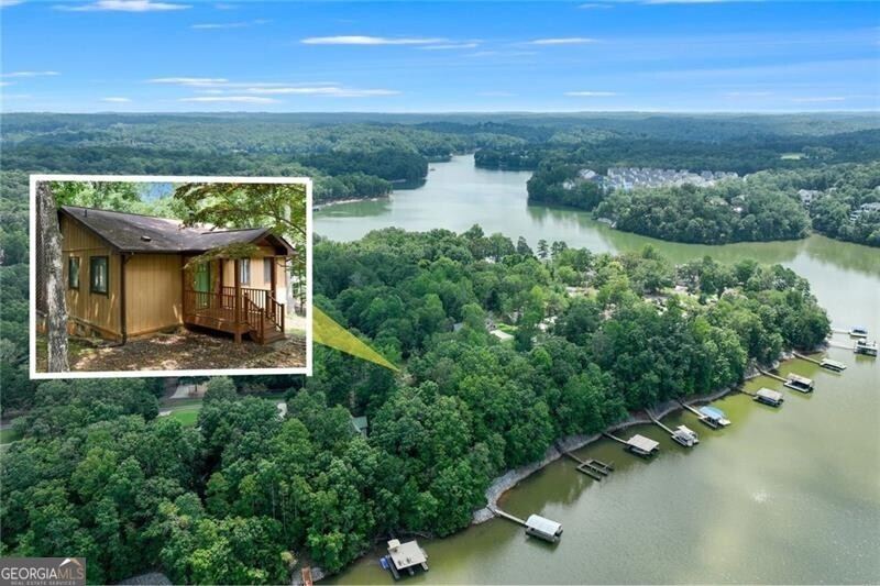 The Lake Lanier cottage you've dreamed of, with an easy walk to the dock and a year round view! A tall vaulted ceiling with rich wood interior is warm and inviting. Enjoy fall with a cozy fireplace in the open great room. The kitchen, dining, and living areas flow seamlessly to a wall of windows (dual French doors) that open to a spacious sundeck-the spot for relaxing and taking in the year-round lake views. A gentle, short walk leads to the single-slip dock, always in great water. The finished terrace level would be ideal as an Airbnb, complete with a full suite and living room area. The basement also offers a large storage or workshop space. Whether you're seeking a full-time residence, a weekend getaway, or an income-producing property, this charming lake retreat is a rare find! Convenient to GA 400 and Dahlonega GA, a popular tourist destination.