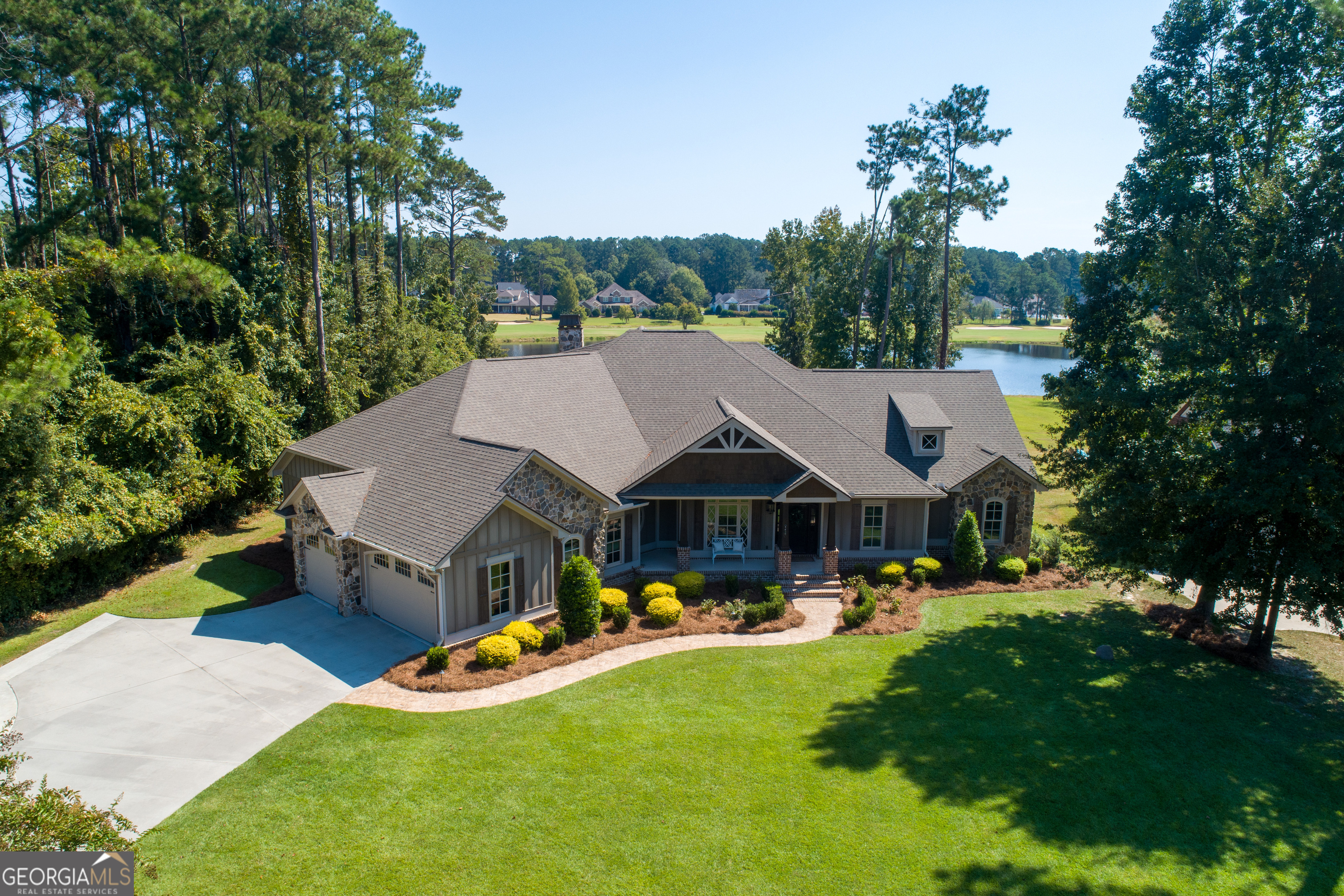 Welcome to your dream oasis! This luxury home boasts unparalleled craftsmanship and stunning amenities, all set against a picturesque backdrop of Lake Neva. The exterior amenities feature stunning, authentic Tennessee Stone and include a buried 250-gallon propane tank that powers the outdoor fire pit, pool, hot tub, and grill. The garage is equipped with insulated doors and has a custom nonslip coating on the floor and back porch. Enjoy optimal temperature control with spray foam insulation in the attic. Aesthetic touches include custom exterior lighting, stunning stamped concrete for walkways and driveways, and an icemaker that has the finest crushed ice. You will enjoy the saltwater pool complemented by a relaxing hot tub. Inside you will find elegant Pelham windows and doors, with hardwood floors, flowing seamlessly throughout the home. The interior wood doors add a at a touch of warmth and sophistication. High ceilings enhance the spacious feel, while the vaulted ceiling in the den showcases beautiful reclaimed wood. The kitchen boasts custom cabinetry, a double oven, and a new GE monogram refrigerator with matching cabinet panels. You'll love the stunning granite countertops, a deep double sink, intricate baseboard ceilings, and an oversized island perfect for cooking and entertaining. The primary suite is a true dream retreat, offering tranquil views of the lake. It feature a generous walk-in closet with custom shelving, elegant tile flooring, a separate soaking tub for relaxation, and a stylish tile shower, creating a perfect blend of luxury comfort. With four spacious bedrooms and 4 1/2 bathrooms, providing an abundance of closet space for all of your storage needs. Additionally, there's a versatile extra room that can serve a variety of purposes, along with two inviting living areas. Don't wait make this luxury Lakeside retreat yours!