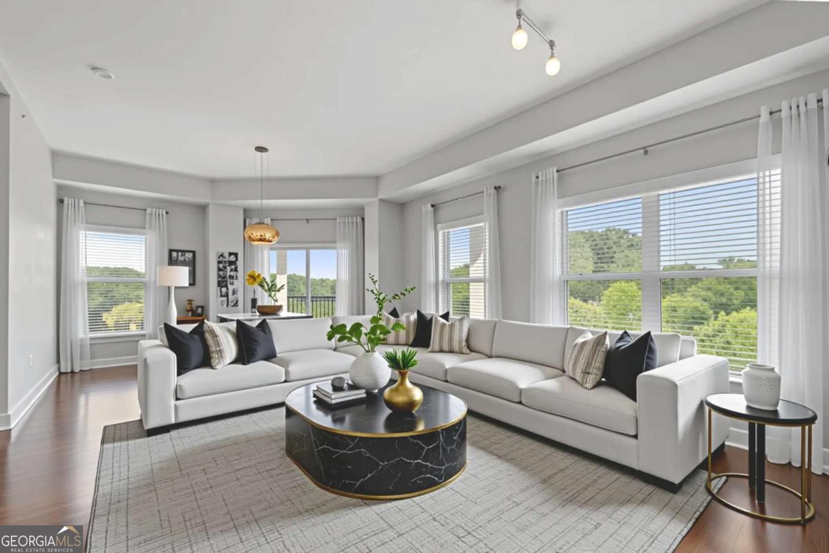 Welcome to the best of both worlds - modern luxury and natural beauty - in one of Atlanta's most sought-after condo communities. Unit #743 is a rare top-floor, corner Penthouse at One River Place in Sandy Springs, offering 2 bedrooms, 2 bathrooms, and an elevated living experience from one of the best positions in the building. Situated on the 7th floor, this light-filled end unit boasts extra privacy, added windows, and a wraparound balcony - perfect for enjoying morning coffee and sunset views. Inside, you'll find an open-concept layout with great natural light, a kitchen island ideal for meal prep or casual dining, and a seamless flow between living spaces. The owner's suite features a double vanity, beautifully tiled shower/tub combo, and walk-in closet. This unit also includes two assigned parking spaces for added convenience. One River Place residents enjoy top-tier amenities including: two pools, a fitness center, spa, clubhouse, dog park, fire pits, grilling areas, and secure kayak and bike storage - not to mention direct access to the Chattahoochee River and trails. The community also offers exclusive gated access to Ray's on the River and hosts frequent events to help neighbors connect. All just minutes from The Battery, golf courses, and with easy access to both I-285 and I-75. Luxury, location, and lifestyle - all wrapped into one exceptional Penthouse retreat.