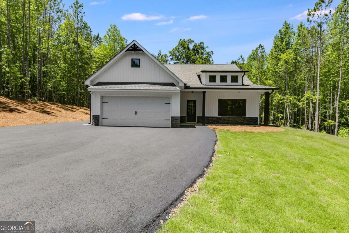 Construction IS ABOUT TO BEGIN! Seize the chance to own your own PRIVATE 10 ACRE lot! This stunning NEW step-less craftsman-style RANCH is designed with modern living in mind! The open floor plan features a vaulted family room with a custom shiplap fireplace. The gourmet kitchen has an oversized ISLAND that is perfect for entertaining & features a charming FARMHOUSE sink. You'll also appreciate the convenience of a separate laundry room & an OVERSIZED PANTRY, providing ample storage and functionality. Every detail exudes luxury and style, making this home inviting and practical. The Gourmet kitchen showcases a CUSTOM ISLAND, FARMHOUSE SINK, STAINLESS APPLIANCES, shaker CABINETS, GRANITE COUNTERTOPS & HUGE PANTRY. The primary suite offers a luxurious ensuite bath with a breathtaking TILE SHOWER & custom glass door, plus a large walk-in closet. Two generous secondary bedrooms provide ample storage with large closets, complemented by a stylish full bathroom. Relax on your picturesque front porch while overlooking your private tree-lined view. The oversized covered back porch is the perfect spot for relaxing & entertaining and features a custom wood-burning OUTDOOR FIREPLACE. This gorgeous modern farmhouse style will include BLACK exterior WINDOWS! Standard features include beautiful exterior vinyl siding, luxury LVP in the kitchen, living room, entry, and baths; plush carpeting in the bedrooms; and high-quality finishes throughout. Enjoy the freedom of a PRIVATE LOT with no HOA restrictions, combining tranquility with convenient access. You still have time to choose your interior and exterior colors to make this home your dream! Not quite the right floor plan or lot? We have other lots and floor plans available! Be sure to inquire about incentives by utilizing our lender, Gareth Thomas, at Silverton Mortgage. Photos are not of the actual home but represent this plan (lot/drone pictures are of the lot).