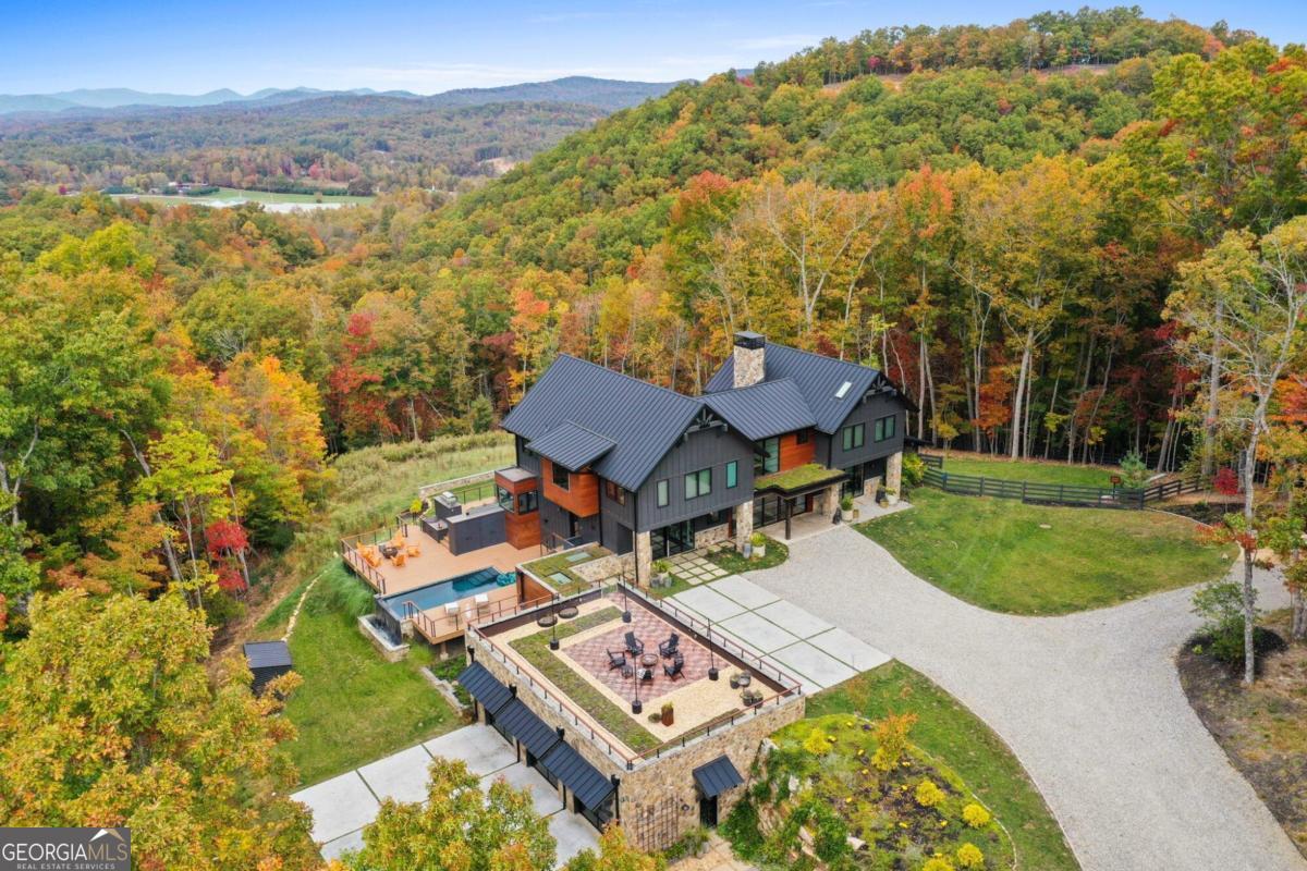 This amazing listing features a one-of-a-kind mountain top estate on one of the last large acreage tracts just 10 minutes from Blue Ridge. Completed connected just 5 minutes from 515. Includes a beautiful main house with state of the art modern amenities and breathtaking views, a fully loaded guest house, private hiking and ATV trails, greenhouse, floating infinity pool and more! Property backs onto US Forest Service for ultimate privacy. This modern mountain home comes fully designed and furnished by award-winning State and Season Home Design and has been featured on HGTV, Architectural Digest and others. Main house has 7 spacious bedrooms with walk-in closets, 2 offices, 2 kitchens, 4 full bathrooms and 1 half bathroom. Guest house has a full kitchen, 1 bedroom and 1 full bathroom (and its own laundry!). Spend your days on private ATV and hiking trails, go horseback riding in the adjacent US Forest Service land, take a swim in the infinity pool, enjoy your dinner on the deck with amazing mountain and sunset views, then settle down with a glass of wine in the hot tub! Ultimate privacy meets connectivity with an industrial generator, whole home water filtration, fiber optic Internet and other touches to make your life in the country as comfortable as possible.