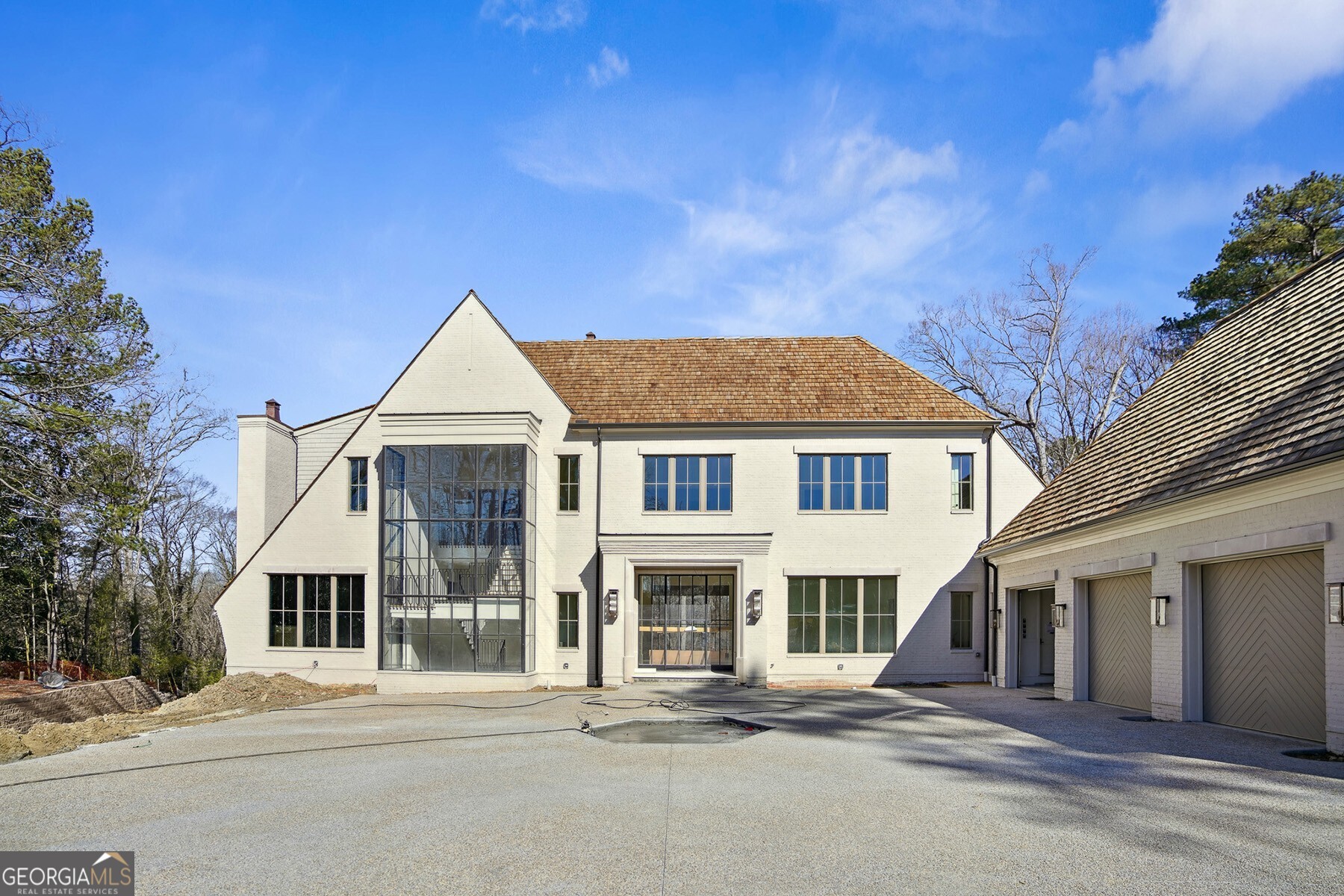 Welcome to a stunning masterpiece in the heart of Sandy Springs - a brand new construction on 2.3+/- acres by Castro Design and Crestar Homes. Upon entering through the grand iron door, the home welcomes you with an abundance of natural light flooding the grand foyer. The stunning open floor plan unfolds with a formal dining room and chef's kitchen boasting a large center island and high-end appliances. A second full kitchen is set behind the main kitchen, enhancing the functionality by creating additional space for catering and entertaining. The fireside living room features iron windows and doors that open to the incredible walkout backyard, creating a seamless indoor-outdoor living experience. The sunlit breakfast room opens to a side patio with an outdoor kitchen and a covered fireside patio, providing the perfect setting for al fresco dining while overlooking the pool and meticulously landscaped turf yard. Completing the main level is a well-appointed office, a convenient laundry room, a show-stopping iron stairwell adorned with floor-to-ceiling glass, and the owner's suite wing. The owner's suite is a private retreat with a spa-like bathroom featuring two vanities, a separate tub and shower, and two very large closets. Upstairs, discover four bedrooms, each with its own en suite bathroom. An additional laundry room adds to the convenience of this level. The basement adds another dimension to this already exceptional property, featuring one full bathroom, as well as multiple rooms suitable for a gym, office space, game room, or TV room. Ample unfinished space in the basement provides storage options, ensuring that every need is met. Many recreational spaces in this home include finished basement, turfed backyard and huge side yard. This brand new construction is a rare gem in the heart of Sandy Springs, offering an unparalleled combination of elegance, functionality, and luxury living.