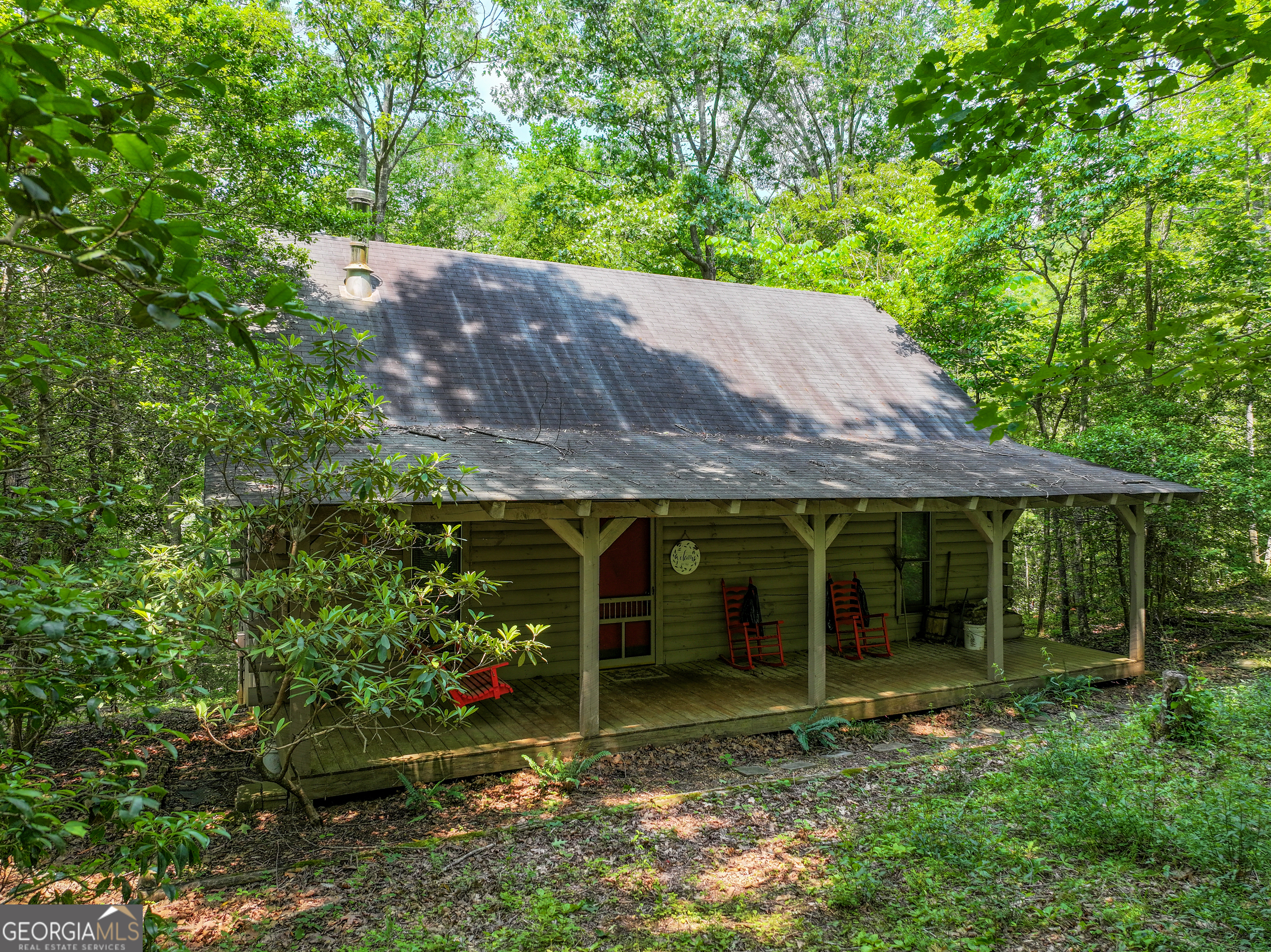 Located in Union County, Georgia, this cozy 3-bed, 2-bath cabin sits on a private 1 +/- acre lot in the beautiful North Georgia mountains! With soaring high ceilings and a rustic wood stove, the open living area offers a warm, inviting atmosphere. Enjoy peaceful moments on the spacious front porch with stunning views. This perfect cabin combines comfort and mountain charm in an unbeatable location!