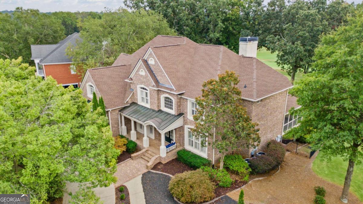 Welcome to 275 Grandmar Chase, an exquisite custom home nestled in the heart of Woodmont Golf and Country Club. This former John Wieland Model Home epitomizes luxury and privacy, perfectly positioned on the 10th Tee Box of the award-winning golf course designed by the renowned Robert Trent Jones, Jr. The home offers expansive breathtaking views of the course and is conveniently located within close proximity from the clubhouse, which features restaurants, a driving range, pool, gym, and tennis and pickleball courts. The elegant design is showcased through its 4-sided brick with stucco accents and professionally landscaped grounds, complete with irrigation and lighting. A convenient fully finished 3-car garage that can be heated or cooled. A circular and side driveway complements the charming front porch, which features custom lighting and brick flooring. Step inside to discover a stunning 2-story foyer with hardwood floors and detailed millwork, all adorned with plantation shutters throughout, even in the garage. The beautifully appointed dining and living areas feature custom lighting, further enhancing the home's elegance. The gourmet kitchen is a chef's dream, boasting custom cabinetry, leathered granite counters, and high-end appliances. A spacious laundry room with a side porch entry adds to the home's functionality. On the main level, an office or bedroom comes complete with an upgraded full bath and access to a screen porch, providing versatile living options. The luxurious master suite upstairs offers a spa bath, custom closets, and a versatile flex room. Three additional large bedrooms offer ample closet space, with one showcasing an integrated bunk and storage system. The finished terrace level is designed for entertainment, featuring a theater room, wet bar, and a walk-out patio, leading to an oversized deck and private fenced backyard. This stunning home combines sophistication with modern amenities, presenting a move-in-ready opportunity in a prestigious community. Additionally, the home is in close proximity to shopping and highly ranked Cherokee County schools, making it an ideal choice when seeking both luxury and convenience.