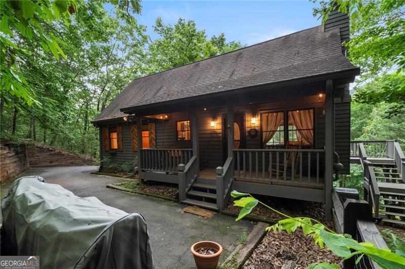 This charming 3 BR - 2 BA cabin has high volume cathedral T&G wood ceiling with exposed beams, hardwood flooring throughout the main level and seasonal mountain views. Wood kitchen cabinets, stone fireplace in the great room, and wood beams in the master b/r which is located on the main level. Expansive wood deck on back and rocking chair front porch on the main level, plus an oversize screen porch on the terrace level. This cabin is located in a very private setting with a year-round running stream located just off to the side of the front porch where you can sit and enjoy endless relaxation and tranquility 24/7. This cottage home can be sold fully furnished and makes for an excellent value with good vacation rental potential. Come see for yourself!