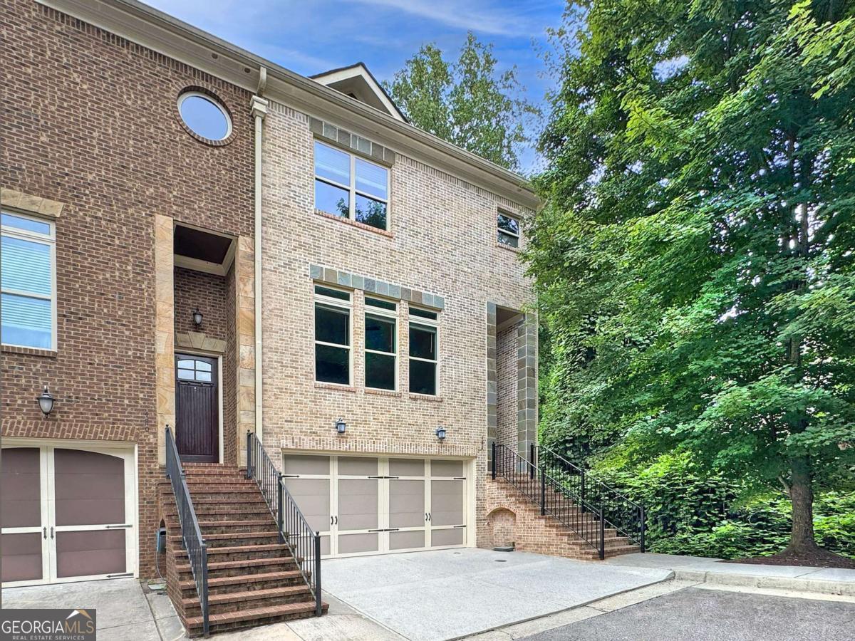 Welcome Home to this gorgeous, move-in-ready, private end-unit luxury townhome in a fabulous Sandy Springs location! A dramatic two-story front entry way sets the tone for the stunning features throughout the rest of this home! The main living level boasts gleaming refinished hardwood floors, luxurious 10 foot ceilings, an open-concept floor plan, and includes an impressive fireside family room with custom fireplace surround and built-ins, open-concept dining area, and beautiful eat-in kitchen compete with striking waterfall granite island, recently painted cabinets, and stainless appliances. Upstairs, you'll find two sizable guest bedrooms, a guest bathroom, laundry closet, and the oversized primary bedroom with spacious ensuite bath including a double vanity, large walk-in shower and large walk-in closet. The lower level includes a full bedroom- perfect for a home office, gym or media room, as well as a full bathroom. Outside, you'll find two cozy decks- one on the main level, and a covered deck on the lower level- both overlooking the private tree-lined perimeter of the community, providing the perfect spot for enjoying your morning coffee or just relaxing! Fantastic location just minutes from GA-400, Historic Roswell, Dunwoody, Chattahoochee River Parks, restaurants, shopping, and more! Hurry! Homes in this friendly, private 9-home community don't enter the market often!