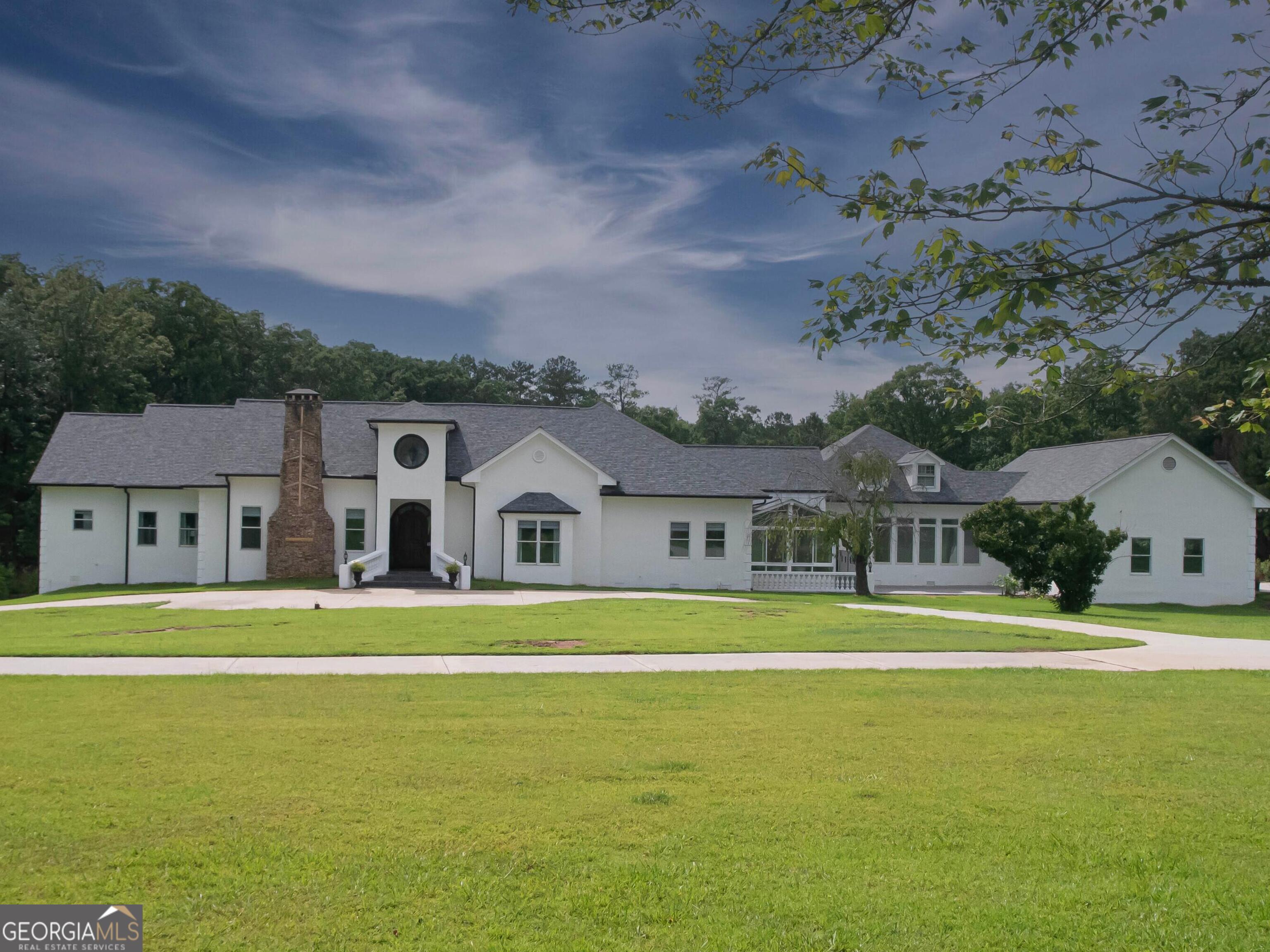 Welcome to country living at its finest! This exquisite 7000+ sq. ft w/ attached 4-car garage Mediterranean rests on over 20 acres with a private 3-acre pond! Attention to detail was given to this custom build, and it's built for entertaining! Three-quarter inch hardwoods and heavy trim back throughout. It's bright, open chef's kitchen is complete with three ovens, 6-Burner Stainless Steel gas range, built-in commercial size refrigerator, as well as a separate beverage cooler. Butler's Pantry also includes built-in refrigerator. There are also two walk-in pantries. The magnificent dining room with domed- ceiling seats over 12 people easily. You will appreciate the separate bedroom plan in this home. All secondary bedrooms on the main level are on the other side of home, two with ensuite baths. Downstairs you will the find the ultimate man cave! This level includes an additional bedroom and full bath with double rain shower. The tastefully crafted commercial-size bar seats 12! Cave is complimented by a regulation size pool table, poker table, and 5 TV's (2 built-in). We've brought the ocean to you, enjoy the calming effect of a 310-gallon saltwater aquarium. What's a bar without a built-in humidor? You've got it! This area leads to another courtyard with additional entertaining space containing extra-large smokeless firepit. Doors abound in this home, that open to a large outdoor living area including built-in commercial grade pergola with outdoor fans, dimmable recessed lighting, and motorized louvers equipped with rain sensors. You will fall in love with the views of the pool, lake, and grand horizon. For nature enthusiasts, the property boasts abundant wildlife. The fully stocked pond contains bass, brim, and catfish. If gardening is more of your speed, 18 newly constructed raised beds await. Currently, several types of summer vegetables and fruit are growing, ranging from watermelon and cantaloupe to zucchini and San Marzano tomatoes. This property houses a newly constructed 24x45 (1080 sq. ft) workshop that has a separate 200-amp electrical service, with the option to upgrade to 400 amps. This estate contains open pastureland, as well as dense wooded areas, perfect for those looking to bring horses. This property is located 45 minutes east of downtown Atlanta and is six minutes away from I-20. Property is in the highest rated school district in Newton. There are also private school options nearby. Shopping, entertainment, and medical complexes just minutes away. Showing appointments only with verifiable pre-approval letters or proof of funds. * CHECK OUT VIDEO TOUR @ 1169HODGESCIRCLE.COM