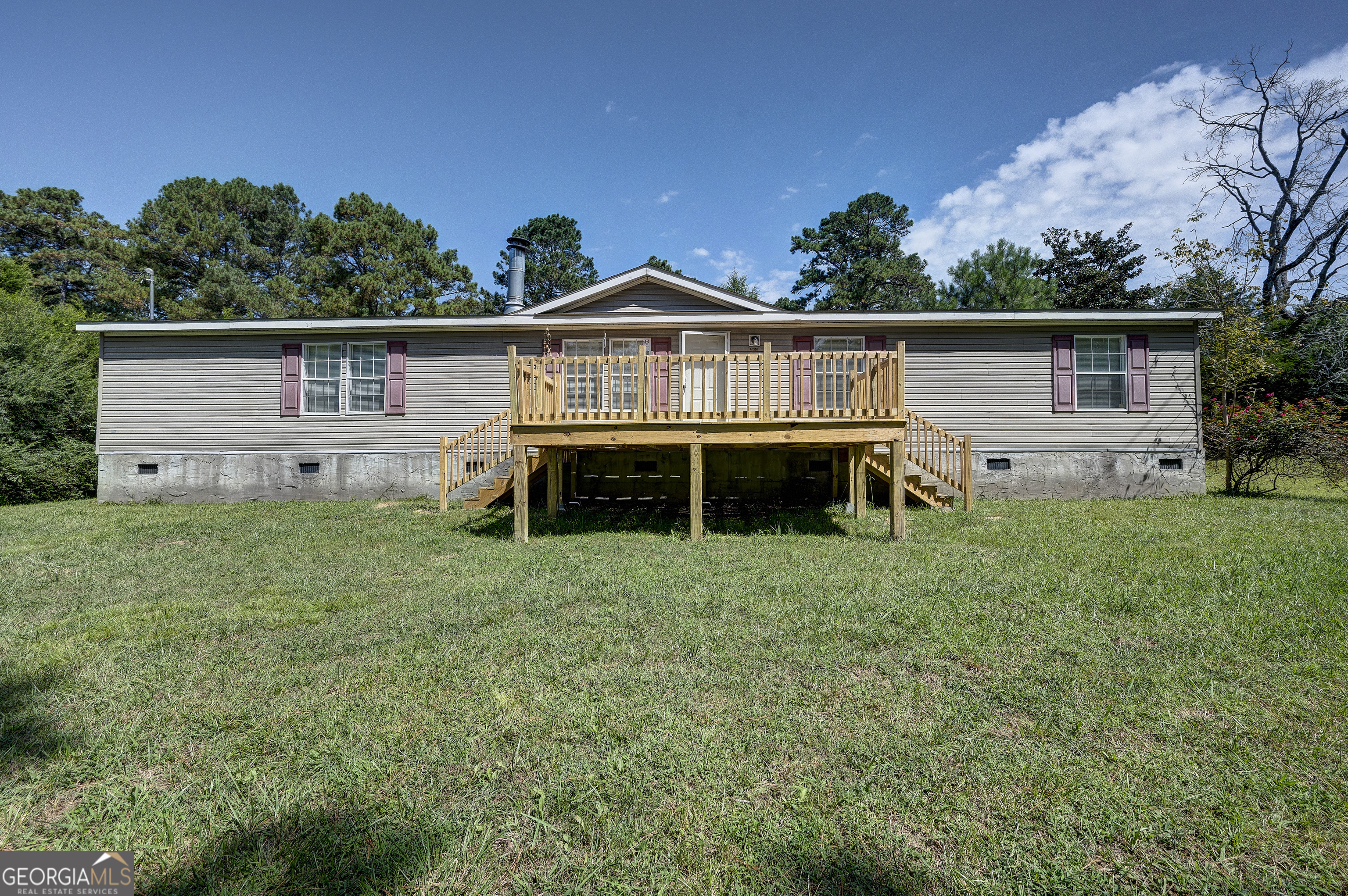 FIVE BEDROOMS ON MILLER FERRY - BIG SPACE, SMALL PRICE TAG TO MAKE IT YOUR OWN! This sprawling, 5-bedroom manufactured home on PERMANENT FOUNDATION is full of potential and offers an affordable option with room to S-P-R-E-A-D out. The FLEXIBLE FLOOR PLAN includes a welcoming layout with plenty of space for everyday living, as well as entertaining. From the BRAND NEW, EXPANSIVE FRONT PORCH with DUAL SIDE ACCESS, enter into the LIVING ROOM, which boasts a ROMANTIC FIREPLACE to create a warm ambiance on those crisp, Autumn nights. The DINING AREA is open to the living room, and leads into the MASSIVE, EAT-IN KITCHEN with CABINET AND COUNTER SPACE GALORE. The OWNER'S SUITE is tucked away from the other 4 bedrooms in a SPLIT-BEDROOM CONCEPT, and features a PRIVATE ENSUITE, complete with LARGE SOAKING TUB and SEPARATE SHOWER. Two of the secondary bedrooms flank a JACK-AND-JILL BATH, and the other two secondary bedrooms share a hall bath, which is conveniently positioned for guest use. This property is equipped with plenty of room to grow, making it a great fit for larger families, or anyone who simply values having extra space. Now is your chance to own a home to make your own that is affordable and ready for its next chapter. Welcome Home to 1653 Millers Ferry Road!