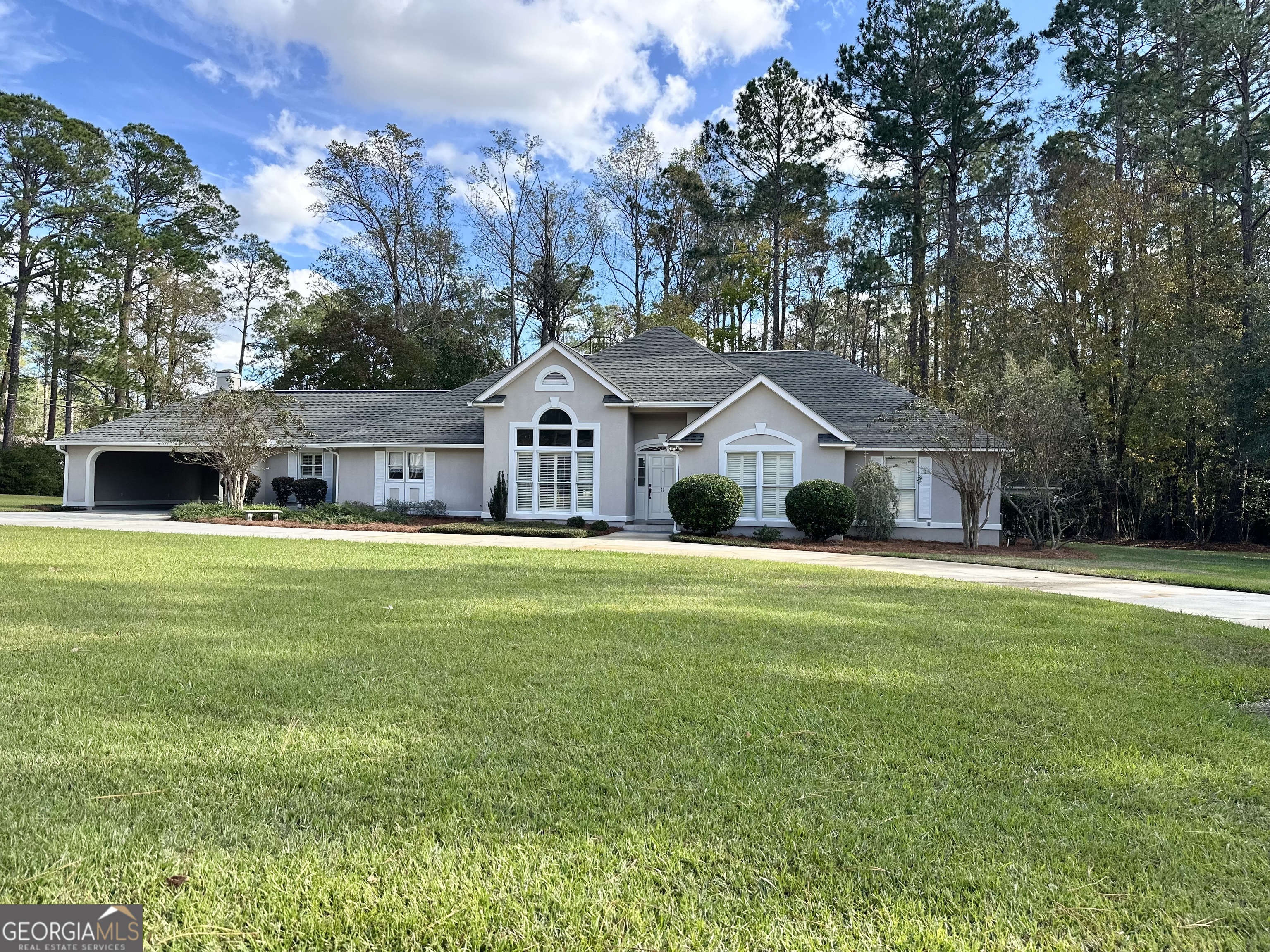 Exceptional Corner Lot Home on 2+ Acres with Endless Charm    Nestled on a sprawling corner lot, this property boasts over 2 acres of beautifully maintained land. With two circular driveways, one passing through an open carport, accessibility is effortless. The backyard is a private oasis, complete with a patio and porch offering serene views, a charming playhouse, and convenient storage tucked beneath the back porch.    Step into the grand entryway, featuring a soaring ceiling that opens seamlessly to the elegant dining room. Floor-to-ceiling windows adorned with plantation shutters fill the space with natural light, while a stunning chandelier and stately columns add a touch of sophistication, leading into the cozy living room. The gas-log fireplace is flanked by dual doors opening to the expansive back porch, perfect for entertaining or unwinding. A stairway to the expandable attic is thoughtfully located here, providing additional potential living space.    Adjacent to the living room, an additional room offers flexibility as a sitting area or formal dining space. The kitchen is a chef's dream with granite countertops, a high-top bar for two, custom shelving, and a massive walk-in pantry. A hallway leading to the bedrooms features abundant storage and a convenient half bath, with an additional half bath located in the laundry room.    The spacious primary bedroom is a retreat, complete with a luxurious Jacuzzi tub, custom-tiled shower, dual vanities, and a dedicated makeup station. Bedroom two includes its own private bath and a large walk-in closet, while bedroom three features a full bath with a tub-shower combo.    Additional amenities include a large storage room within the garage and countless thoughtful touches throughout the home.    Call Susan Evans Realty today to schedule your private showing of this remarkable property!