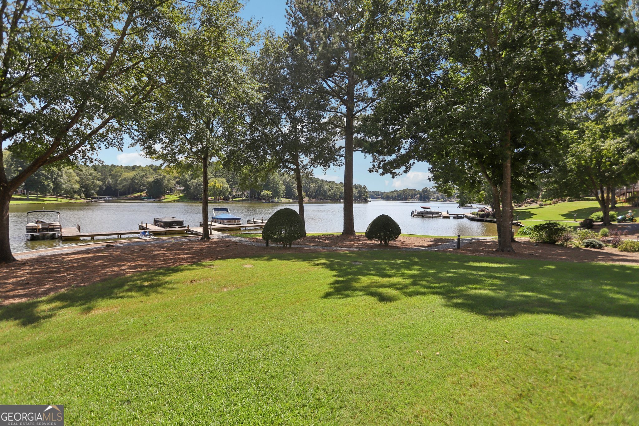 Lake life living, look no further than this waterfront beauty. This home features two master bedrooms, one on the main and one on the upper level. Each of the bedrooms has views of the lake. There is a spacious kitchen and dining space for entertaining family and friends. This is an open concept home that provides great views of the lake throughout. This beautiful spacious home is a lake lover's delight on the highly sought Lake Oconee in a gated golf course community. There are tons of amenities for members to include pool, pickleball, fitness center, restaurant and bar, marina, dog park, walking trails and more. There is also access to the Wharfside owners boardwalk and beach. This beautiful villa comes with its own boat slip. This is a rare opportunity so get your offers in!!