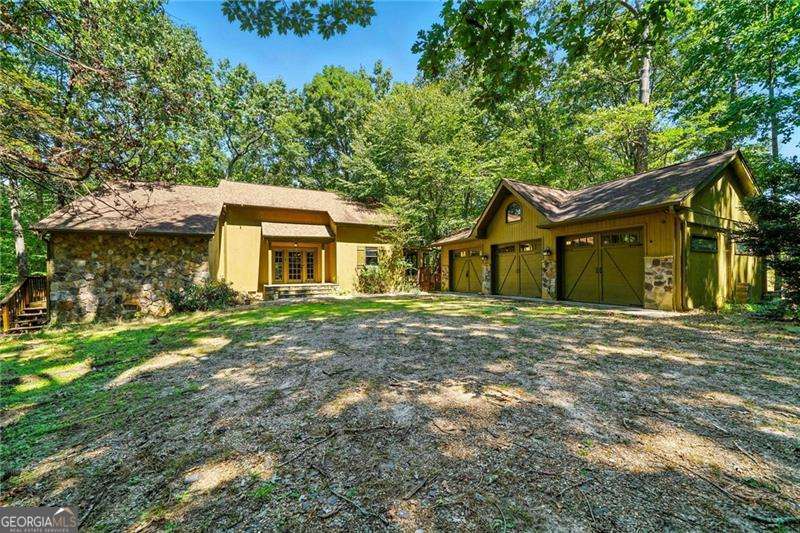 Bring your vision to this rare find in one of Suwanee's most sought-after areas! Nestled on over 2.17 ACRES, this property offers endless possibilities-renovate the existing home with its solid structure and unique architectural features, or start fresh and build your dream estate from the ground up. The existing home features 4 spacious bedrooms, 3 full bathrooms, and gorgeous beamed ceilings, creating an open and airy feel with tons of natural character. While the home needs a full renovation, the bones are strong and full of potential for the right buyer looking to restore or reimagine the space. A major bonus is the detached 3-car garage in excellent condition-perfect for storage, a workshop, or future guest house conversion. Enjoy peace and privacy with no HOA restrictions, while being just minutes from top Gwinnett County schools, parks, shopping, dining, and more. Whether you're an investor, builder, or homeowner ready to customize your forever home, this is a rare land and location opportunity that won't last! PLEASE DO NOT WALK ON THE DECK OFF THE KITCHEN TOWARDS THE GARAGE. IT IS NOT STABLE.