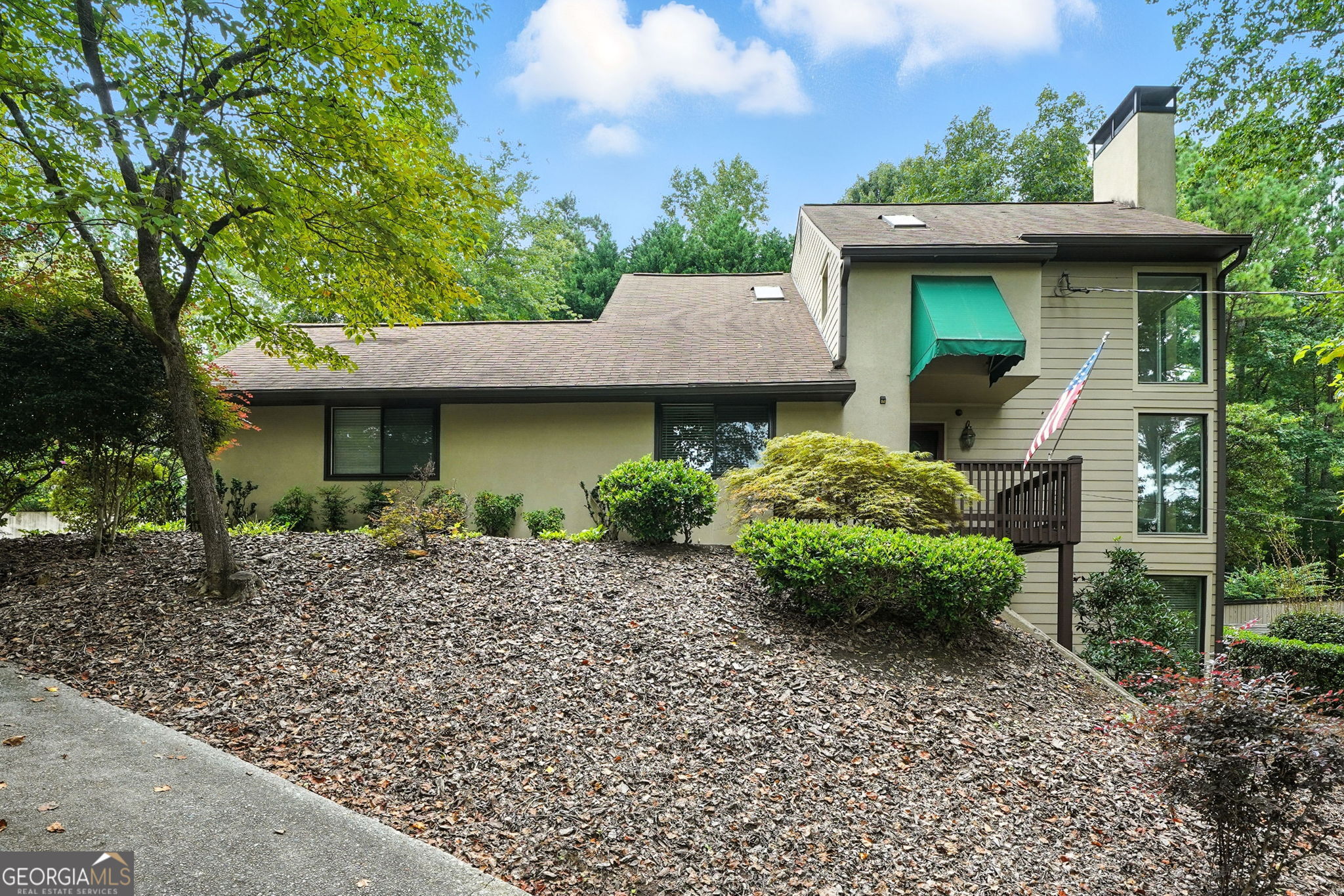 **Location, Location, Location!** *Close to everything Marietta has to offer, Shopping, Dining, Schools and more!* Come in to this open living room that impresses with soaring two-story windows filling the home with natural light and a tranquil views. The generous dining area is perfect for entertaining. The kitchen features a professional grade stovetop and wall oven with a large wood-topped island prep area. Abundant cabinetry, and a cozy eat-in area along with a desk make it complete. The main level offers a guest bedroom and full bath. Upstairs, the oversized primary suite boasts two large closets in the bathroom, a stepless shower and a skylight in the shower gives ample space to unwind. An additional bedroom includes a full bath and double closets. The finished basement expands your living space with a large family room featuring built-in bookcases, a full bath, wet bar, and a spacious storage room. Tucked away on a private, serene lot, this uniquely designed home welcomes you with a long, wooded driveway and beautiful hardwood floors. Enjoy the spacious screened-in porch or host gatherings on the open back deck overlooking the landscaped backyard. A true peaceful retreat, this property combines privacy, comfort, and beautiful natural surroundings.