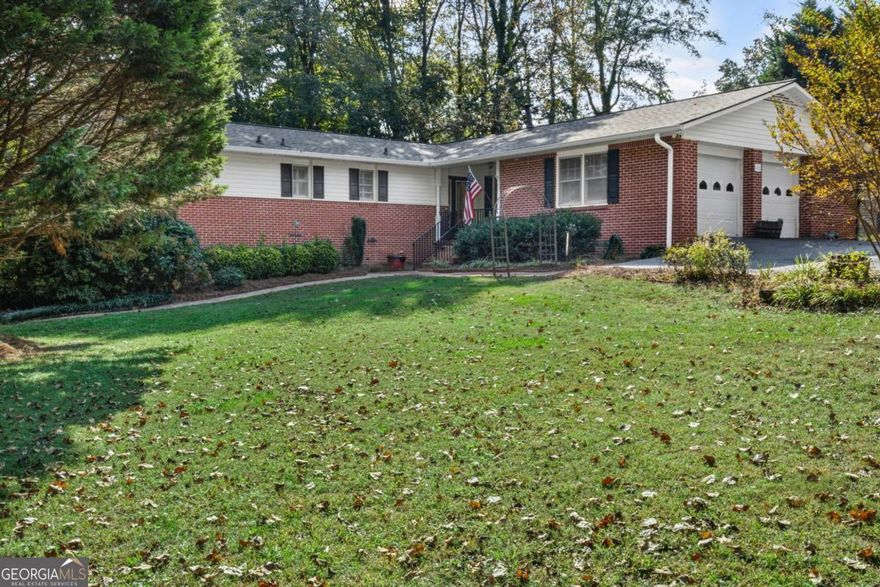 WELCOME to ONE LEVEL LIVING with a FULL FINISHED TERRACE LEVEL on nearly 1 ACRE with NO HOA!!! This incredibly SPACIOUS 3BR/2BA home features a REMODELED KITCHEN with WOOD CABINETS, QUARTZ COUNTERS, STAINLESS APPLIANCES, and an incredible amount of STORAGE. The OVERSIZED FAMILY ROOM centers around a cozy fireplace and built-in shelving and opens to a MASSIVE HEATED & COOLED SUNROOM with TONGUE & GROOVE ceilings-an ideal spot for relaxing or entertaining year-round. The primary suite includes two closets and a private bath with walk-in shower, while two spacious secondary bedrooms share an updated hall bath. The finished basement adds approximately 1,400 SF of flexible space, including an additional fireside family room, office area, full bath, and plenty of storage. Enjoy the outdoors and sounds of nature on three decks--all 3 were just painted and they are ready for your enjoyment.  The OVERSIZED DRIVEWAY IS PERFECT FOR YOUR TOYS & there is room for RV PARKING. Just MINUTES from CUMMING CITY CENTER, excellent schools, shopping, dining, and parks, this home offers the lifestyle you've been looking for; WELCOME HOME!