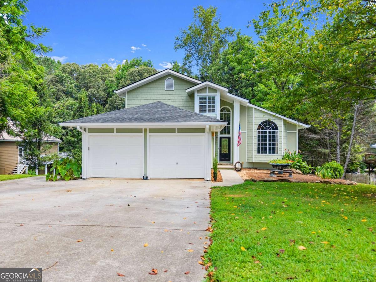 Stunning home in Dawsonville, that backs up to a large Lake Lanier Corps of Engineers peninsula with lake views and exceptional privacy. As you enter, you're welcomed by an open layout filled with natural light, true hardwood floors, and an oversized dining room that seats 12+ people. The spacious kitchen features granite countertops, an island, and great views of the private backyard and Corps land. The cozy living room includes a fireplace, creating the perfect space for gathering and relaxing. The main level also offers a guest bedroom and half bath, ideal for visitors or extended family. Upstairs, the large master suite includes a double-sided fireplace, a spacious bathroom, and serene views. An additional bedroom and full bath are also located on the upper level. The fully finished terrace level is perfect for multi-generational living or potential rental income. It features two bedrooms, a full bath, a full kitchen, a living room with fireplace, and a separate driveway and private entry. Beautiful landscaping, open living spaces, and direct access to Corps land make this a rare and versatile property you won't want to miss. Conveniently located just minutes from War Hill Park, public boat ramps, HWY 400, and North Georgia Premium Outlets. Schedule your showing today!