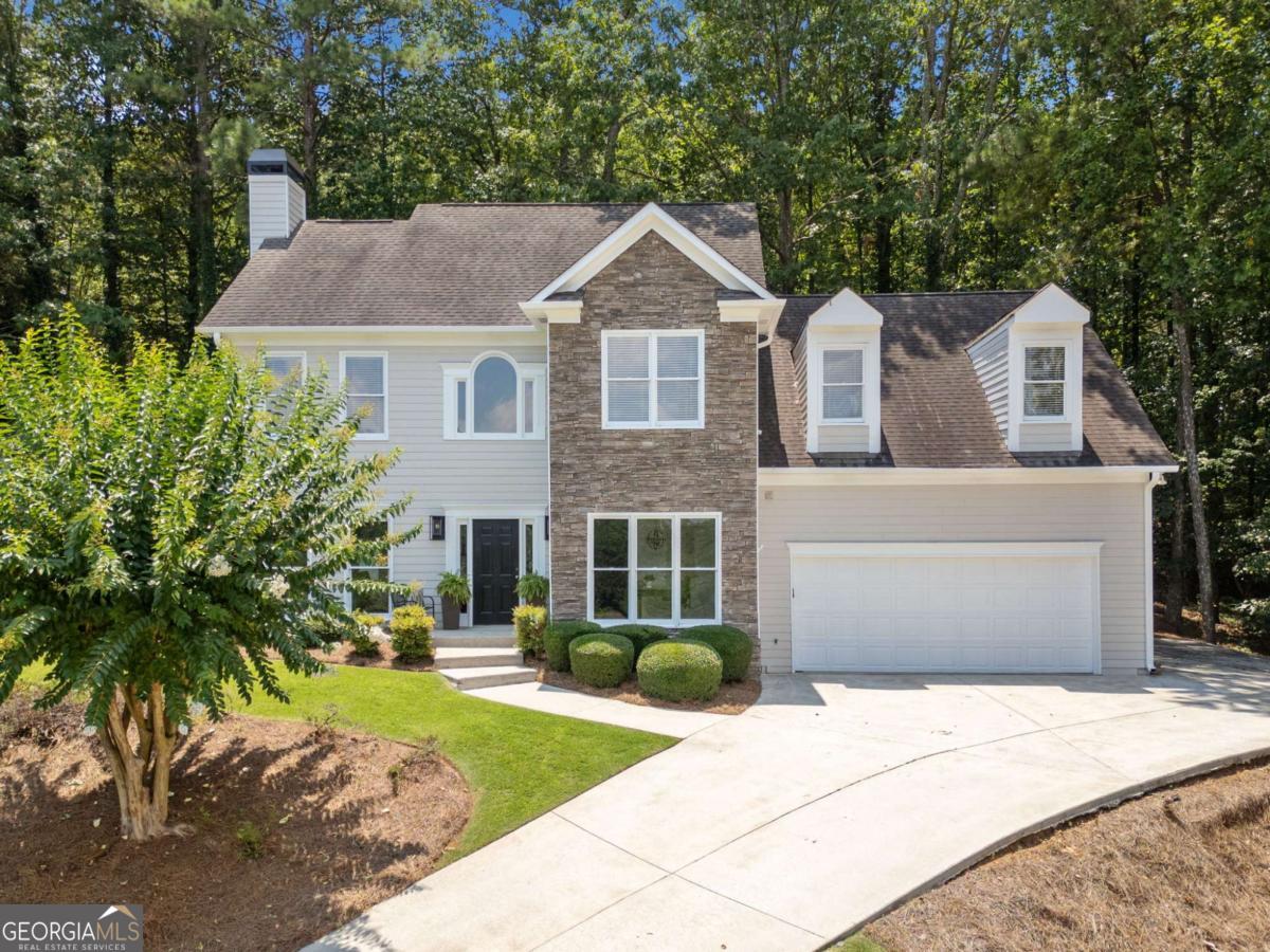 Nestled in the charming Wyngate community of Woodstock, Georgia, this meticulously cared for 4-bedroom, 2.5-bathroom residence boasts an inviting open concept design, fresh interior paint on the upper level, and a peaceful cul-de-sac location. The main floor radiates warmth and brightness, showcasing a thoughtfully designed layout. Featuring a generous space, LVP flooring throughout, a pristine white cabinet kitchen outfitted with stainless steel appliances, a stylish tiled backsplash, and elegant granite countertops, this home also includes large breakfast room windows that frame views of the patio and the serene woods behind. You'll adore the family room, anchored by a cozy gas fireplace, where abundant sunlight pours in, seamlessly connecting to the kitchen, dining area, foyer, and office. The spacious primary suite is complete with an en-suite bathroom featuring a double sink, a relaxing soaking tub, and a roomy walk-in closet. The three additional secondary bedrooms, one notably large, are ideal for children or guests. The garage is generously sized to accommodate vehicles, a motorcycle, gym equipment, and offers ample storage space. A trail in your backyard leads you to the pool and playground. Enjoy a low-maintenance yard on a cul-de-sac street in this highly desirable community with top-rated schools. Residents of Wyngate benefit from a variety of amenities, including two sparkling swimming pools, illuminated tennis and pickleball courts, a basketball court, and a playground.