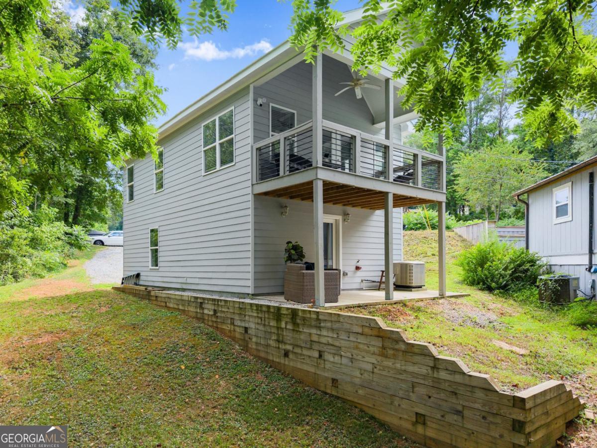Lake Lanier Living at Its Best! Welcome to this stunning 2-bedroom, 2-bathroom home built in 2020, offering year-round views of Lake Lanier and access to fantastic community amenities. Located in a gated community, enjoy peace of mind along with a boat ramp, dock, and pavilion. Step inside the upper level and you'll find a bright, open floor plan featuring a gorgeous white kitchen with a large island, granite countertops, and stainless steel appliances. The kitchen overlooks the spacious living room with vaulted ceilings and direct access to a covered deck with breathtaking lake views - the ideal spot for morning coffee or evening relaxation. Also on the upper floor is a bedroom and a full bathroom, along with a conveniently located laundry room. Downstairs, you'll discover a second bedroom and full bath, along with a covered patio - great for guests, roomates, or multi-generational living. The oversized garage offers ample space for lake toys, storage, or a workshop. Boats allowed to be parked on property! Whether you're seeking a full-time residence or a weekend getaway, this property offers a rare combination of modern comfort, water access, and natural beauty. No rentals allowed in the neighborhood.