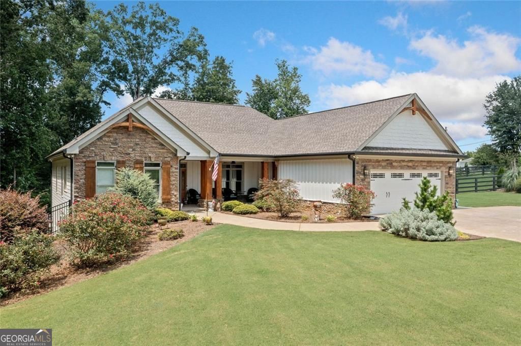 Immaculate Custom Ranch on 2 Usable Acres in Hickory Flat - Impeccable Craftsmanship, No HOA! Welcome to this designer's showcase, thoughtfully updated and meticulously maintained, this 3 bedroom, 2 full bath home offers the perfect blend of main-level living, flexible spaces and peaceful privacy. This light and bright home boasts numerous upgrades and newly constructed custom builds including an amazing outdoor living space complete with stone fireplace, tongue and groove ceiling with wood beams, and porch swings. An open and airy floor plan with hardwoods throughout, accent walls and ceilings, all new light fixtures, and a complete Sonos surround system inside the home. The new kitchen is a show stopper with custom white cabinets to ceiling, 12' quartz island, coffee bar, drink fridge, all new GE Cafe appliances, custom vent hood with LED lighting, walk in pantry and a secondary pantry with hardwood shelves. The spacious primary bedroom surprises with an impressive custom closet complete with island, plenty of storage and natural light. The primary's en-suite is beautifully updated and includes a double vanity and a secondary closet. The secondary bath boasts a new remodel with beautifully tiled walkin shower. The basement mirrors the main level in size, has an extra garage and is plumbed for a kitchen, a laundry room and two bathrooms. Bring your own design. Updates continue on the exterior with all new exterior paint, cedar columns, gables and shutters. Electronic gated fence, new driveway made for an RV in the back of the house with added amp power for the RV. All new gutters, landscaping, driveway, sod. All of this on a private street yet conveniently located to shopping and dinning and a sought after High School district. Minutes to downtown Canton, Milton and Roswell.