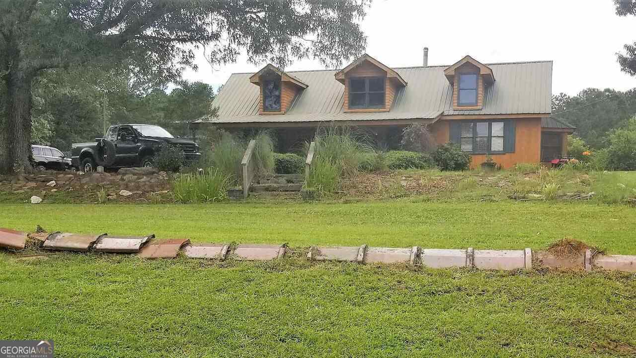 Welcome to country living! This property has a log cabin with 14 sprawling acres. 3 beds, 2 baths with a loft that can be used for however you want. Main living area has a wood burning stove. The laundry room is spacious enough for extra storage. In the heat you can cool off in the inground swimming pool. There is also a 3-bay garage/shop with electricity. Book your showing today!