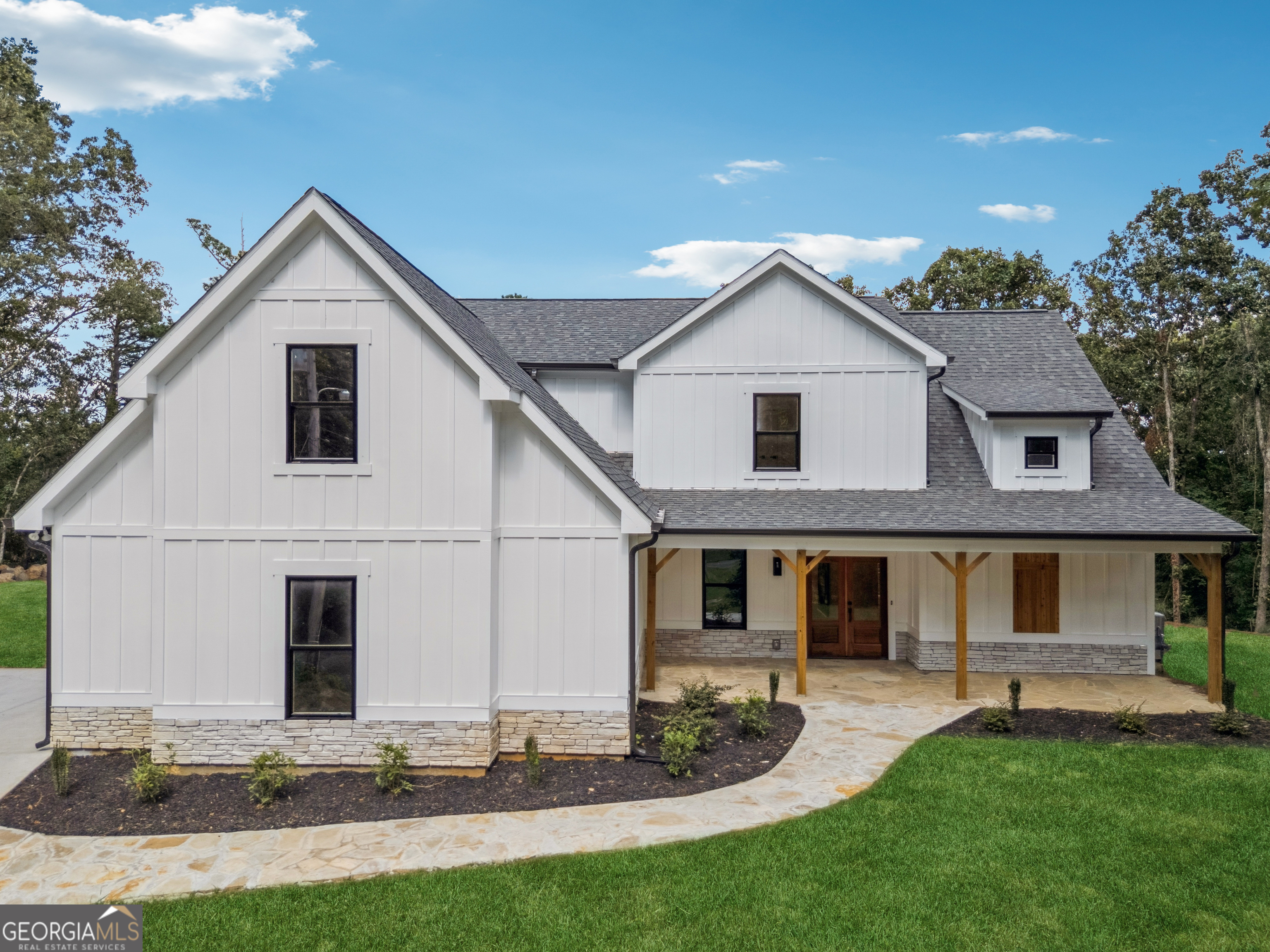 Don't miss the opportunity to live in this NEWLY BUILT GEM, located in the heart of Woodstock. Situated on a quiet cul-de-sac with NO HOA, this residence offers privacy, style, and convenience-just 5 minutes from vibrant Downtown Woodstock, with easy and quick access to Alpharetta and Roswell, with an excellent school district, including the highly regarded RIVER RIDGE HIGH SCHOOL. A rare combination of location, design, and value in one of the area's fastest-growing communities. Designed with a modern ranch-style layout, this home features a unique floor plan that opens with a spacious foyer leading into a vaulted great room and open-concept kitchen with soaring 16-foot ceilings that enhance the natural light and open feel. The kitchen is equipped with custom cabinetry, quartz countertops, a center island, gold-tone fixtures, and stainless-steel appliances. The Master Bedroom is located on the main floor and offers a spa-like bathroom with double vanities, a separate shower and tub, and a walk-in closet. In total, the home includes four bedrooms, three full bathrooms, and one-half bath. The second level features 9-foot ceilings and well-designed spaces ideal for family or guests. Enjoy over 1,000 square feet of covered porches overlooking a wooded view-perfect for outdoor living and entertaining, providing a total built area of 4051 sqft. The property also features an ELJEN septic system, known to have a durability of up to 100 years.