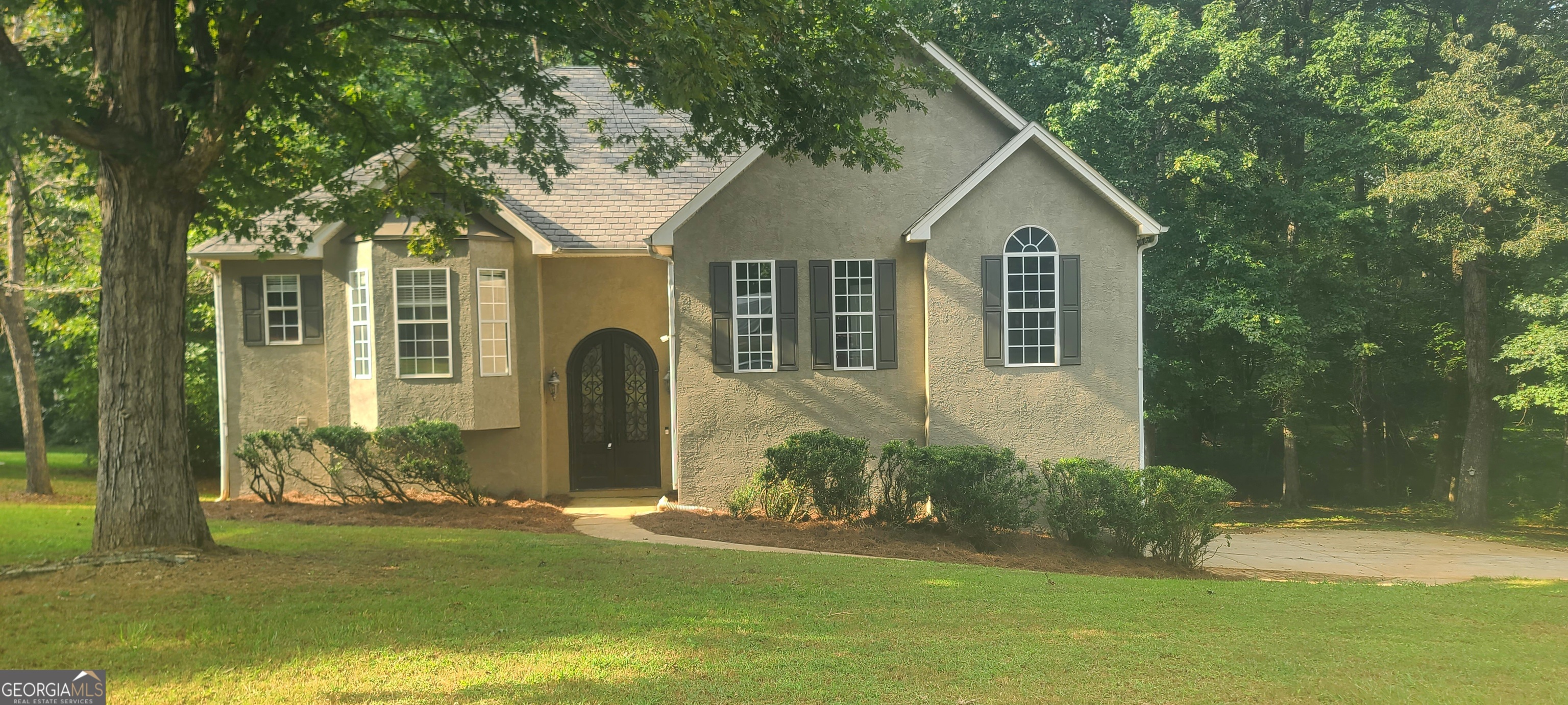 Step through the elegant arched doorway into a grand 2-story foyer, where soaring ceilings and flowing hardwoods set the tone for a home that feels brand new. Professionally renovated from top to bottom, every detail has been refreshed-giving you the rare chance to enjoy a move-in-ready lifestyle with no projects for years to come. The exterior has also been freshly painted, including shutters and bay window caps, giving this home instant curb appeal. The vaulted great room makes a statement with its striking stone fireplace and sleek new Windmill ceiling fan. The kitchen is a showstopper: all-new Shaker cabinetry, stainless appliances (including gas range), Carrera White Quartz counters, new sink and faucet-all opening to a light-filled dining area and new deck with modern goat-wire railings. Retreat to the oversized primary suite with double banks of windows, vaulted ceilings, and space for a sitting area. The spa-style bath is completely reimagined with new vanity, mirrors, lighting, fixtures, and all-new ceramic tile that extends seamlessly through the floors and bathtub surround for a uniform, polished look. Nearby, the spacious walk-in closet offers plenty of storage. Secondary bedrooms and bathrooms shine with the same level of detail-new fans, hardware, vanities, mirrors, lighting, and updated tubs/showers. The daylight basement is enormous, already includes a finished full bath, and is just awaiting simple sheet-rock and your choice of flooring. It wouldn't take much to complete, making it the perfect opportunity to create a secondary living space, home office, or recreation area. Outside, enjoy the peace of a private backyard surrounded by nature. A large 600 sq ft garage with a new opener and attached workshop adds even more flexibility. All of this in a cul-de-sac location, just minutes from I-85, Peachtree City, and highly sought-after schools. With fresh renovations and a price below market, this home is expected to move fast-don't miss your chance!