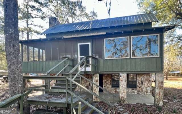 Located down a quiet dirt road, this riverfront retreat offers picturesque views of the Altamaha River. Its features include 2 bedrooms on the main level separated by a jack and jill style bathroom, a loft on the upper level with a full bathroom, and a half bath on the bottom level. Enjoy views of the river from multiple locations on the property including the dining room, the screened-in porch, the deck, or the private, floating dock. This property also has its own covered outdoor area with firepit and food prep amenities. Perfect for the avid fisherman or anyone looking to enjoy life on the Altamaha.