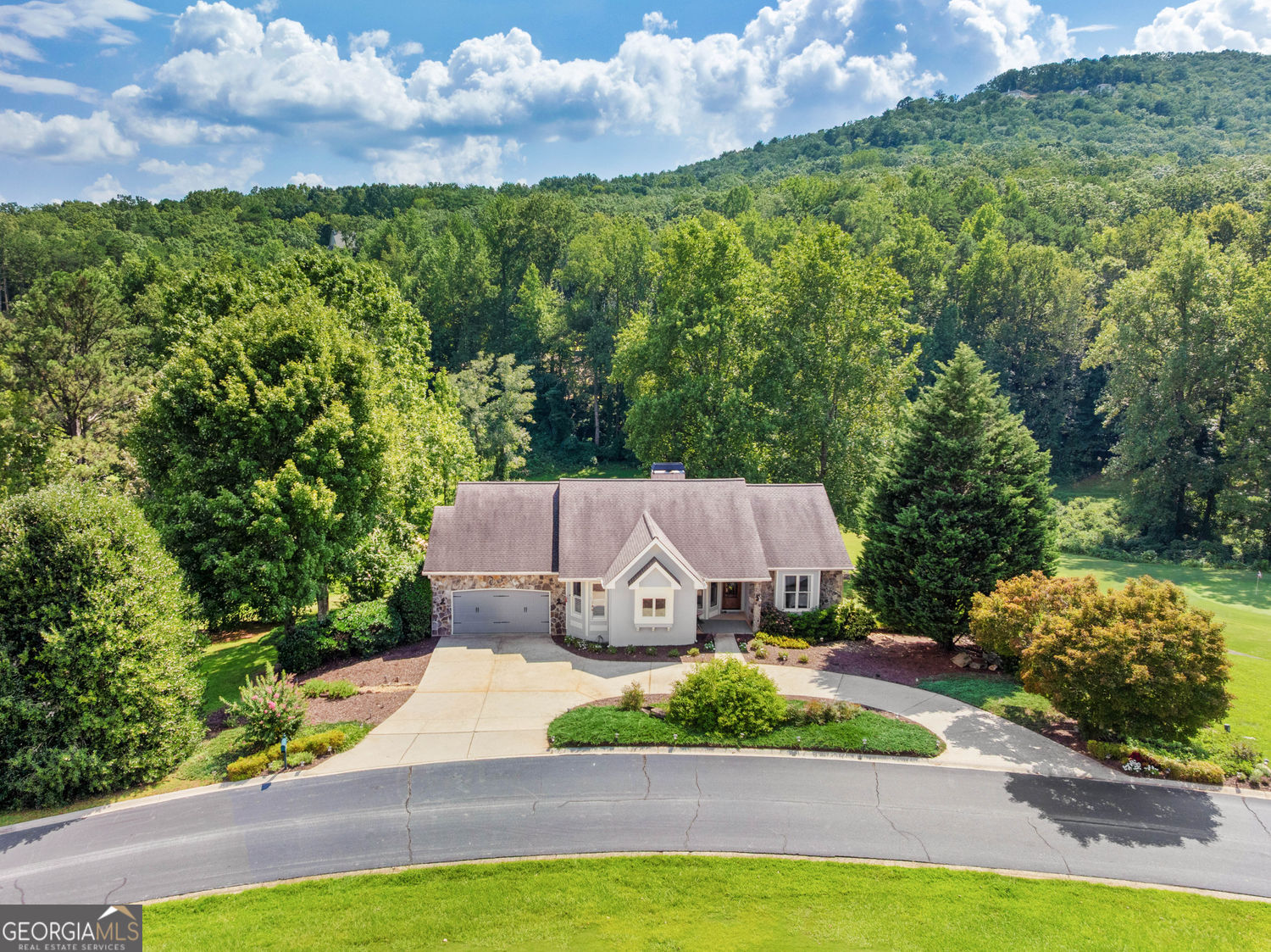 Updated 4BD/3.5BA, 2,928 sqft golf-front cottage in The Orchard Golf Community. Perched on a hillside overlooking the 13th Green and framed by sweeping mountain views, this home offers an ideal blend of privacy, style, and country club living. The main level features wide-plank hardwoods, a stone fireplace, shiplap accents, elegant moulding, and designer lighting. A separate dining room with built-ins and tray ceiling adds timeless character. The chef's kitchen boasts a butcher block island, solid-surface countertops, walk-in pantry, and full stainless appliance suite. The luxurious master suite includes a tray ceiling, dual vanities, oversized tiled shower, and spa-like soaking tub. The newly finished terrace level expands the living space with a game and media room complete with wet bar and undercounter fridge, a guest suite with en suite bath, generous storage, and access to a screened veranda and walk-out patio. Set on a private 0.79-acre lot fully buffered by Orchard Golf & Country Club property-without neighboring lots or homes-this residence guarantees exceptional privacy. Additional highlights include a circle drive, terraced gardens with mature landscaping, and a two-car garage with workshop and storage space. The Orchard is a friendly and vibrant private golf club community in the beautiful mountains of Northeast GA with gated access and 24-hour security, championship golf course, newly renovated clubhouse, pool and brand new tennis and pickleball amenities. Convenient to Clarkesville, Tallulah Falls and Clayton and only 90 miles from Atlanta.