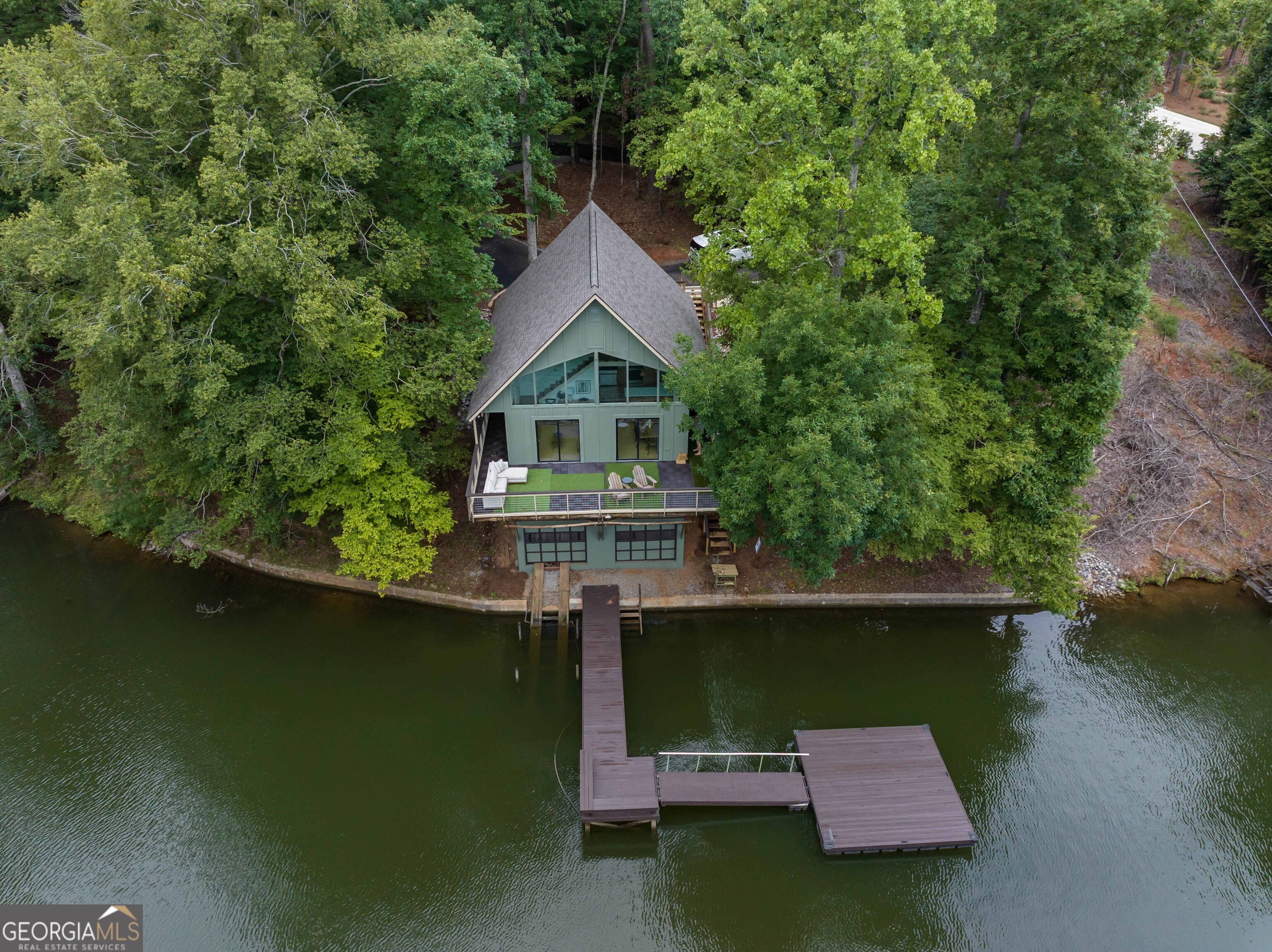 Lakefront Living at Its Finest - With the Charm of a Blue Ridge Retreat! This beautifully renovated 3BR/3BA home rests right at the water's edge on a rare 1.3+ acre DEEDED lot on Lake Harding. Tucked away at the end of a long, winding drive beneath a canopy of mature hardwoods, the property offers the serene, tucked-in-the-trees feeling of Blue Ridge-peaceful, private, and naturally picturesque. Inside, the home has been fully remodeled with modern finishes, a brand-new roof, updated HVAC, and upgraded kitchen appliances. Open living spaces capture sweeping water views, creating the perfect backdrop for relaxing evenings or entertaining family and friends. Outdoors, a spacious dock makes it easy to welcome guests by boat, while a concrete seawall adds both function and character to the shoreline. Best of all, Lake Harding stays full year-round and does not draw down in the fall or winter, so you'll enjoy consistent, beautiful water access in every season. Whether you're searching for a full-time lake residence or a private weekend retreat, this property offers the best of both worlds-mountain-retreat charm with year-round lakefront living. Don't miss your chance to own this rare DEEDED waterfront gem on Lake Harding!