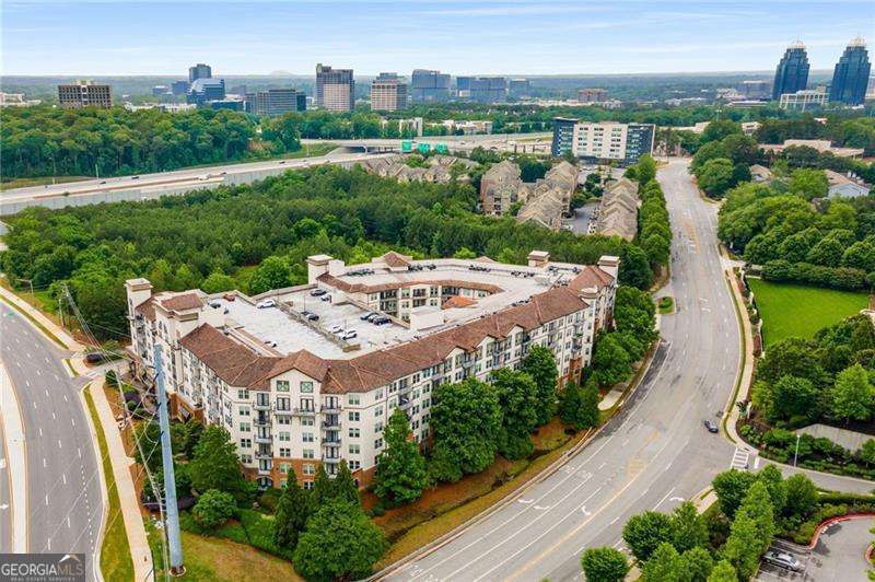 Exceptional value and convenience await in this beautifully updated 3-bedroom, 2.5-bath condo at The Serrano, ideally located between Sandy Springs and the Perimeter. Priced below market with the lowest price per square foot in the building, this ground-level unit offers rare dual access-both private exterior entry and interior hallway access-perfect for pet owners or anyone seeking step-free living. Inside, you'll find a bright and open layout with a granite kitchen, breakfast bar, and spacious living and dining areas that open to a private patio. The oversized primary suite features a soaking tub, separate shower, double vanities, and a large walk-in closet. Two additional bedrooms share a well-appointed hall bath with a double vanity. Enjoy resort-style amenities including a newly renovated pool with cabanas, fitness center with sauna, outdoor fireplace and grill area, theater room, club room, and concierge services. Two deeded garage parking spaces are located just steps from your door. Minutes to top hospitals, dining, shopping, and MARTA-this is the best in low-maintenance, lock-and-go living.