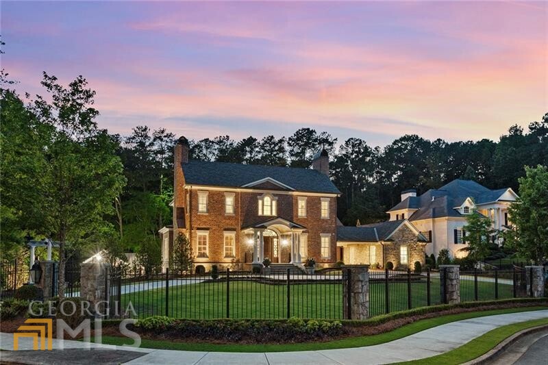 Experience absolute perfection! Nestled on an immensely private 1+/-acre lot bordering the Kennesaw Mountain National Battlefield, this exquisite gated brick and stone estate was envisioned by Harrison Design and is laden with luxurious details. No detail was overlooked nor expense spared in this thoughtfully curated masterpiece. The enchanting grounds include a heated saltwater pool, a professional resistance current pool, a seven-hole putting course, a sport court with a pickleball and half basketball court, a batting cage, a synthetic-turf recreation yard, a trampoline pit, a built-in firepit, a screened porch and a flourishing vegetable and flower gardens. The interior impresses with Francois & Co. Chequer marble floors, groin-vaulted ceilings, a barrel-vaulted entry portico, a three-stop elevator, Francois & Co. limestone fireplaces, 12-foot ceilings, intricate molding, designer lighting and an elaborate full-home automation system. The stunning upper-level primary suite features a beamed and vaulted ceiling, a limestone fireplace, a spa-inspired marble-clad bathroom with dual vanities with in-mirror televisions, separate water closets, a clawfoot bathtub, and a retail store-sized walk-in closet with lighted, glass-enclosed custom cabinetry. The finished terrace level offers an additional fireside family room, a theater, a fitness studio, a temperature-controlled wine cellar, a craft room, a guest suite and an armor-plated saferoom. The newly constructed pool house invites with a fully equipped kitchenette, a light-filled open floor plan, a guest suite and a pool bathroom with direct access to the exterior, a washer and dryer and a large walk-in shower. Additional features include an oversized four-car garage, solar panels, spray foam insulation, interior and exterior cameras and audio system, a well-water system for irrigation and extensive night-scape lighting. Enjoy proximity to Marietta Square, Wellstar Kennestone Hospital, an array of excellent schools, Kennesaw State University and McCollum Field International Airport