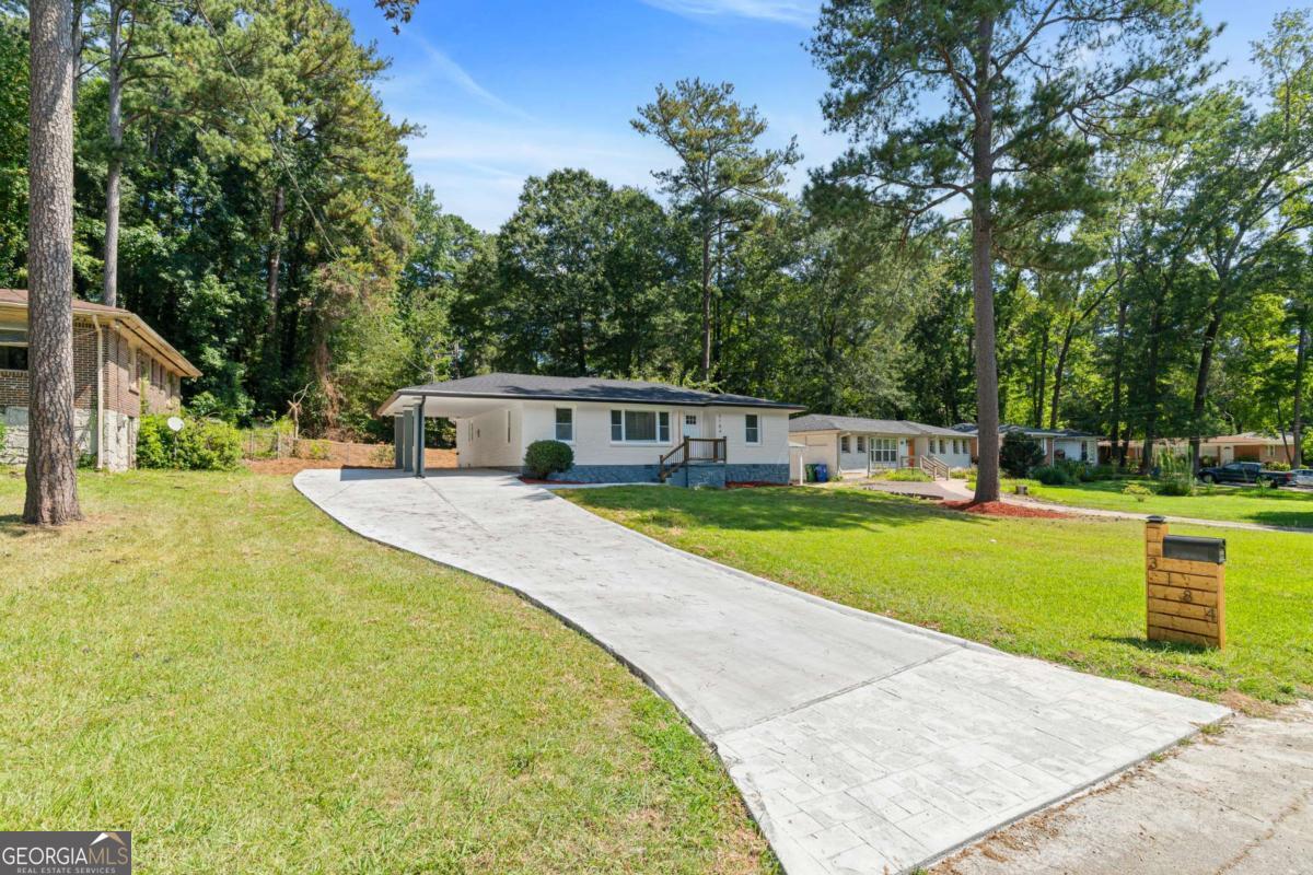 Welcome to 3184 Pinehill Drive, a Fully Renovated and Expanded Bungalow on a super quiet street in Decatur! This Gorgeous 3 Bedroom, 2 Bathroom single story home seamlessly blends Modern Updates with Timeless Charm. As you step inside the home, the first thing you will notice is the Open Floor filled with tons of natural light and refinished hardwood floors throughout. The Living Room is located to the left and flows nicely into the Kitchen and Breakfast Area towards back of home. Kitchen features White Shaker Cabinets with soft-action close doors and drawers, Quartz Countertops, Island with Breakfast Bar and a Full Suite of Stainless Steel Appliances. Laundry Room is located just off the Kitchen near the back entry door. The Primary Suite is tucked away in the back of the home for privacy. Spacious Primary Bedroom with Recessed Lighting, Tons of Light, Generous Walk-In Closet and Direct Access to Deck overlooking the backyard. The Ensuite Bathroom features a large Shower with Sliding Glass Door and Double Vanity. The Secondary Bedrooms are located on the right side of the home and share a convenient Secondary Bathroom, making this home perfect for families or guests. Brand New Roof, Water Heater and Furnace. Brand New Concrete Driveway with ample off-street parking for at least 4+ vehicles. Walk-In Crawlspace great for Storing Lawn Tools or Additional Storage. Property has easy access to I-285, I-20 as well as Downtown Decatur and Avondale Estates for all your Restaurant, Shopping and Entertainment.