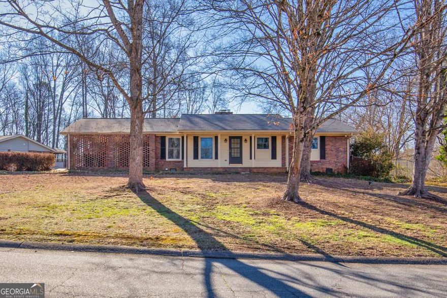 This charming ranch is situated on a bend towards a cul-de-sac in the sought after Piedmont Hills subdivision which resides in the Sprayberry High School District. This location enjoys minimal traffic in the community and itCOs about a 5 minute drive to I-575 and Barrett Pkwy. Excellent Location, convenient to dining, all sorts of shopping, grocery: Publix 0.3 miles, Kroger 2.5, Aldi 2.3, KSU, Town Center Mall (1.5 miles), Noonday Trail (walk, run and bike trail) 0.5, and Wellstar Kennestone Hospital, 4.2; all of this and much more are located within 5 miles. This location lives up to the benefits of a live, work, play, lifestyle.    CGood BonesC, the craftsmanship and construction of homes built in the 1960s have a durable structure reputation. This unique 4-bedroom, -3 bathroom home is moderately sized yet is compartmentalized for maximum utility to suit a variety of buyers. Enter the galley style kitchen from the two-car carport; makes unloading groceries easy. The laundry/storage area is on one end of the kitchen and on the opposite side is a dinette area that opens into the family room. Your enclosed serene sunroom for relaxing with beverage and a good book is accessible from the family room. Three bedrooms, including one of two primary bedrooms are located down the hallway from the family room; there is a full bath located in that hallway. There is a living area just off the family room that can be used for the traditional or creative mindset. The flooring in the main living areas are hardwood. There is a private enclosed patio that overlooks a fully fenced backyard, ideal for outdoor activities. The spacious second primary bedroom is accessible from the family room and sits on the back side of the home. It features a modern bathroom and tiny kitchenette. This area, with its own access from outside would be perfect for a mother-in-law suite or space for short term/long term rentals.   This meticulously maintained, move-in ready residence has an HVAC system that was serviced in October 2024, a roof that was replaced in 2020 and energy efficient double pane windows. Schedule your tour today and experience the comfort and convenience this property offers! This home is located in a community with no HOA, no fees or rental restrictionsCooffering the ultimate in convenience and flexibility.