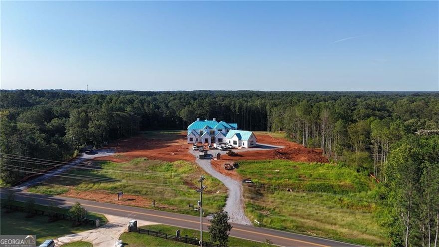 Set on over 12 acres in the heart of Milton, this private gated estate offers a rare blend of luxury, lifestyle, and land. Currently under construction by award-winning Loudermilk Homes, this custom-designed 11,000+ square foot residence features 5 bedrooms, 6.5 bathrooms, and a layout that brings together refined architecture with relaxed, everyday living in one of Georgia's most sought-after communities.     This thoughtfully planned floor plan balances grand entertaining and personal retreat, beginning with a main-level primary suite that serves as a serene escape featuring a spa-style bath with dual oversized dressing rooms, and direct access to a covered terrace overlooking the resort-style pool and expansive grounds. At the heart of the home, a chef-inspired kitchen with double islands, a separate prep kitchen, walk-in pantry, and top-of-the-line Wolf and Sub-Zero appliances connects seamlessly to the living and dining areas, combining function and elegance in equal measure. The terrace level expands the experience with a full bar, poker room, fitness space, and multiple finished storage areas, while a state-of-the-art low voltage system integrates whole-house audio, home advanced security, and future-ready smart home capabilities. Upstairs features additional spacious bedroom suites with walk-in closets and en-suite baths, along with elevator-ready framing for long-term convenience. Expansive covered patios blur the line between indoor and outdoor living, with a custom pool perfectly positioned to capture the natural beauty of the landscape. A poured pad is already in place, offering future potential for a guest house, car barn, pool house, or equestrian facilities-allowing the property to evolve with your vision. From the moment you pass through the gates, the sense of arrival is undeniable-this is a home that lives as beautifully as it entertains. Whether you're hosting large gatherings or enjoying quiet evenings under the stars,  every element has been curated with intention. Just minutes from top-ranked schools, local dining, and scenic parks, and less than an hour from both Buckhead and Hartsfield-Jackson Atlanta International Airport, this rare offering captures the essence of Milton living: elegant, timeless, and deeply connected to both community and land.