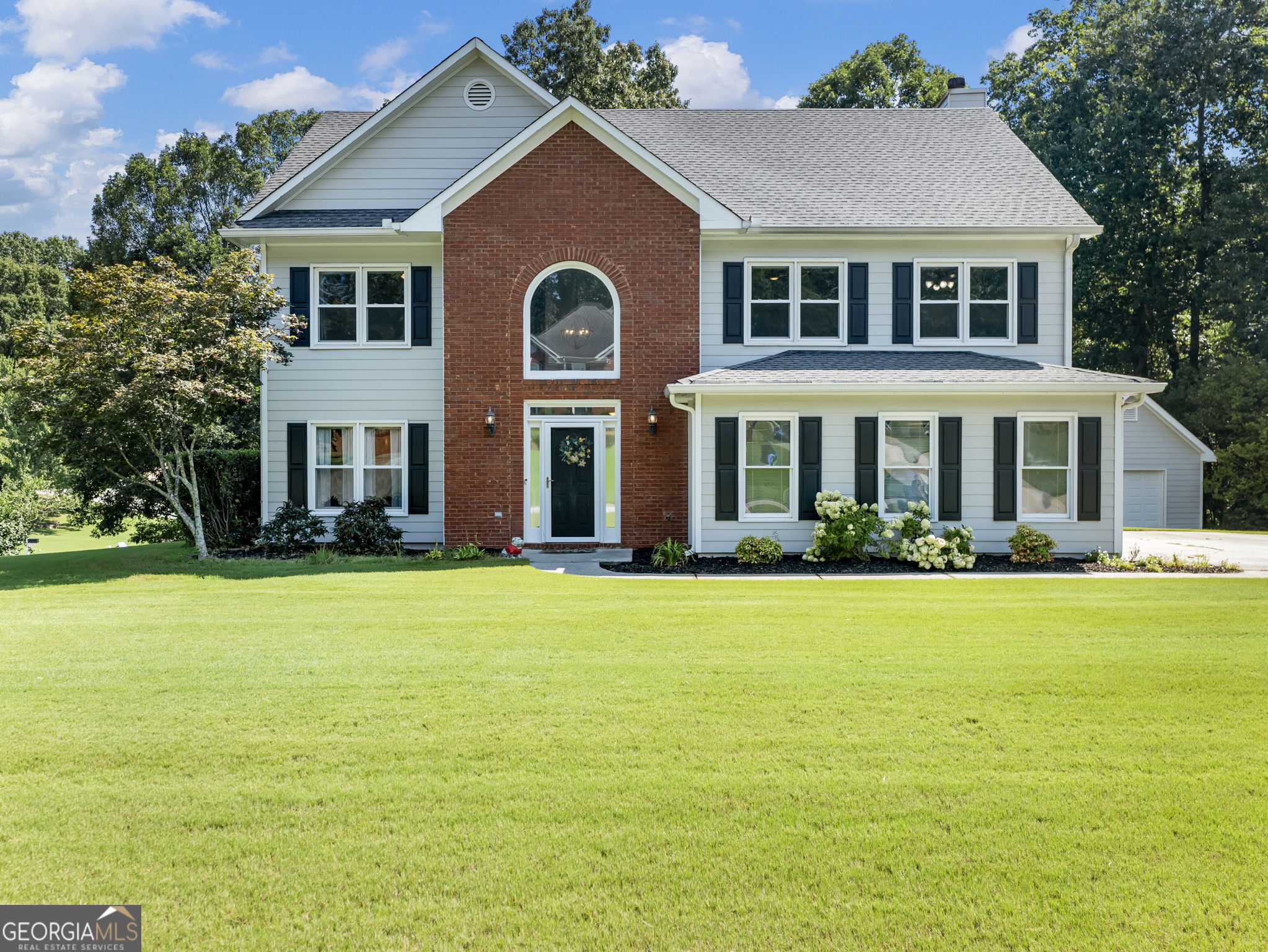 Gorgeous 5 bedroom 2 and a half bathroom home located in the heart of Dacula. This well-maintained home offers an open floor plan, hardwood floors throughout the main floor, separate dining room, office or play area for the kids. The staircase with rod iron balusters brings you to the 2nd floor where your spacious master bedroom with vaulted ceiling is located. The master bathroom with a separate water closet offers privacy and comfort to the home. Two spacious bedrooms offer large closets and built-in bookshelves great for the kids' books or perfect for the home office plus two additional spacious bedrooms. The house is situated on a large lot with professional landscaping. Bonus! Outbuilding with air conditioning and electricity! Great for a workshop, man cave or just for extra storage. Perfect home with perfect location, rare find! A must-see home in Dacula and sought after Mill Creek School District!