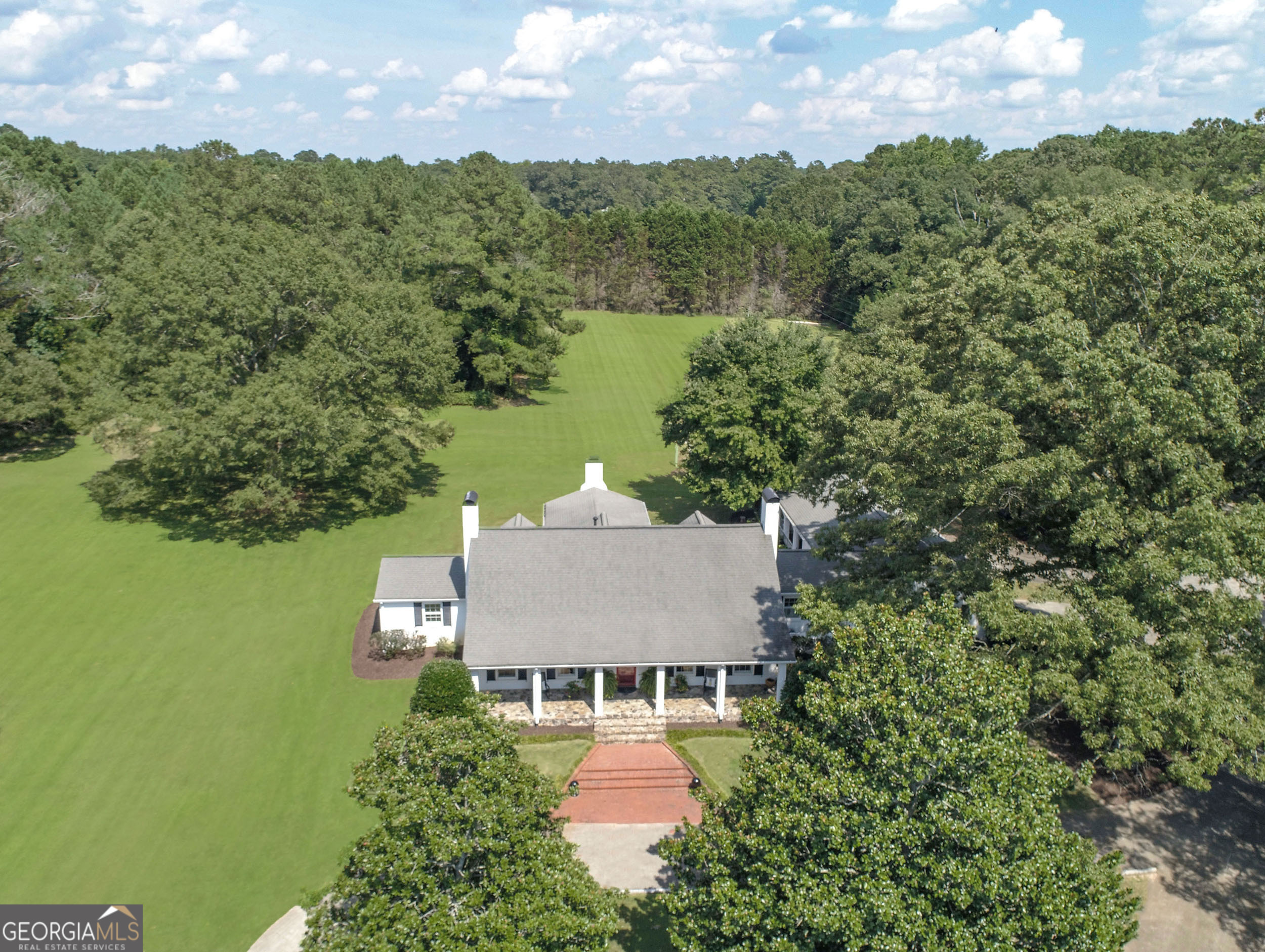 "A LITTLE BIT OF HEAVEN BORDERING THE FLINT RIVER JUST TWO MINUTES FROM BROOKS!" THIS MAJESTIC 60 ACRE GATED ESTATE IS TRULY A "MAGICAL PARADISE" SURROUNDED BY BEAUTY AND WILL SIMPLY TAKE YOUR BREATH AWAY! UPON ENTERING THE STATELY STONE GATE, THE SPARKLING 3 ACRE SPRING FED POND SETS THE STAGE FOR THIS BEAUTIFULLY RESTORED FARMHOUSE, SIMPLY DRIPPING WITH CHARM AND CHARACTER...PLUS SEPARATE HISTORIC GUEST COTTAGE, AND AN ADORABLE POND HOUSE PERFECT FOR HOURS OF RELAXATION OR FISHING! OF COURSE, THERE IS ALSO THE PICTURESQUE RED BARN, FENCED PASTURE AREAS, AND LUSH TREE-LINED TRAILS LEADING TO THE FLINT RIVER TOO! This gorgeous farmhouse has been tastefully renovated with all the latest trends and decorator touches! Pause for a moment on the flagstone front porch and enjoy the water views, gorgeous gardens, lush landscaping, and mature hardwood trees for complete privacy! STEP INSIDE this lovely showplace to be AMAZED! YOU WILL FALL IN LOVE WITH THIS SPECTACULAR GREAT ROOM enhanced by dramatic 18' cathedral ceilings, hand hewn exposed beams, and stunning floor to ceiling stone fireplace...plus sliding doors opening to an inviting brick patio and gigantic covered pavilion...surrounded by nature and the stars at night! Continue on the inside tour to an elegant dining room for 12+ guests complete with a beamed ceiling, interior creamy white brick wall, and hardwood flooring, which extends throughout entire main level! Chef's "dream" kitchen equipped with handcrafted cabinets, granite counters, brick wall, bookcases, TV cabinet, and upscale stainless appliances including a Dacor 5 burner cook top, dual Kitchen Aid ovens, and dishwasher! There is also a granite wet bar with Kitchen Aid ice maker across from the kitchen! A "real" mud room complete with huge walk-in pantry, half-bath, and spacious laundry room with beverage cooler! The luxurious owner's "wing" is conveniently located on the main level, complete with amazing Restoration hardware spa bath enhanced by raised tumbled travertine vanity, dual sinks & travertine flooring, Kohler faucets, and gigantic walk-in decorator shower! In addition, the guest bedroom or exec office/library is also on the main level enhanced by brick fireplace and custom cabinetry! Take the stairs to 2 bonus suites with dormer windows and a decorator hall bath right out of a magazine! AND THERE IS MORE...A FULL UNFINISHED BASEMENT FOR STORAGE OR FUTURE EXPANSION, PLUS OVERSIZED 2 CAR GARAGE WITH WORKSHOP AREA ON THE KITCHEN ENTRY LEVEL! NOW FOR THE POND HOUSE: Relax or fish for hours in the pond house...the adorable front porch leads into wide open-vaulted great room surrounded by windows and kitchenette area, all with panoramic water views (Approximately 625 sq ft)! THIS HISTORIC 1938 GUEST COTTAGE is a delightful "walk back in time" and has been preserved to perfection! Totally livable with a great room, open dining, kitchen, 2 bedrooms, bath, and laundry room, separate electric & heat too! THE ENTIRE PROPERTY IS A "TRUE TREASURE" AND "OPPORTUNITY OF A LIFETIME!" PRIME LOCATION WITH QUICK ACCESS TO BROOKS, PEACHTREE CITY, SENOIA, TRILITH, SHOPPING, AND RESTAURANTS! PLEASE COME SEE FOR YOURSELF!