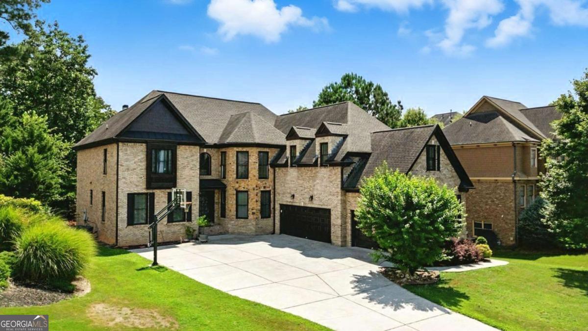 Don't miss this exceptional home in one of Suwanee's most desirable communities! Located within the award-winning North Gwinnett School District, this stately four-sided brick home offers an unbeatable combination of location, space, and quality. Being close to downtown Suwanee, you'll enjoy easy access to local parks, restaurants, walking trails, and family-friendly events throughout the year. Set on a beautifully landscaped lot, the home features a side-entry three-car garage that enhances both curb appeal and functionality. Inside, you'll find refinished hardwood floors, elegant trim work, and a flowing floor plan designed for both comfort and style. The gourmet kitchen is equipped with top-of-the-line stainless steel appliances and opens to a vaulted keeping room with a cozy fireplace, perfect for everyday living or entertaining. The impressive two-story great room features a second fireplace, built-in shelving, and overlooks the fenced, professionally landscaped backyard-an ideal space for gatherings or play. A main-level office or study provides a quiet, private work-from-home area. Upstairs, oversized bedrooms each have access to a private full bathroom, offering both luxury and privacy. The finished terrace level adds incredible flexibility with two additional bedrooms, a full bath, and multiple entertainment areas-perfect for movie nights, a game room, or extended guest stays. From top-rated schools and thoughtful design to its unbeatable location near everything Suwanee has to offer, this home truly has it all.
